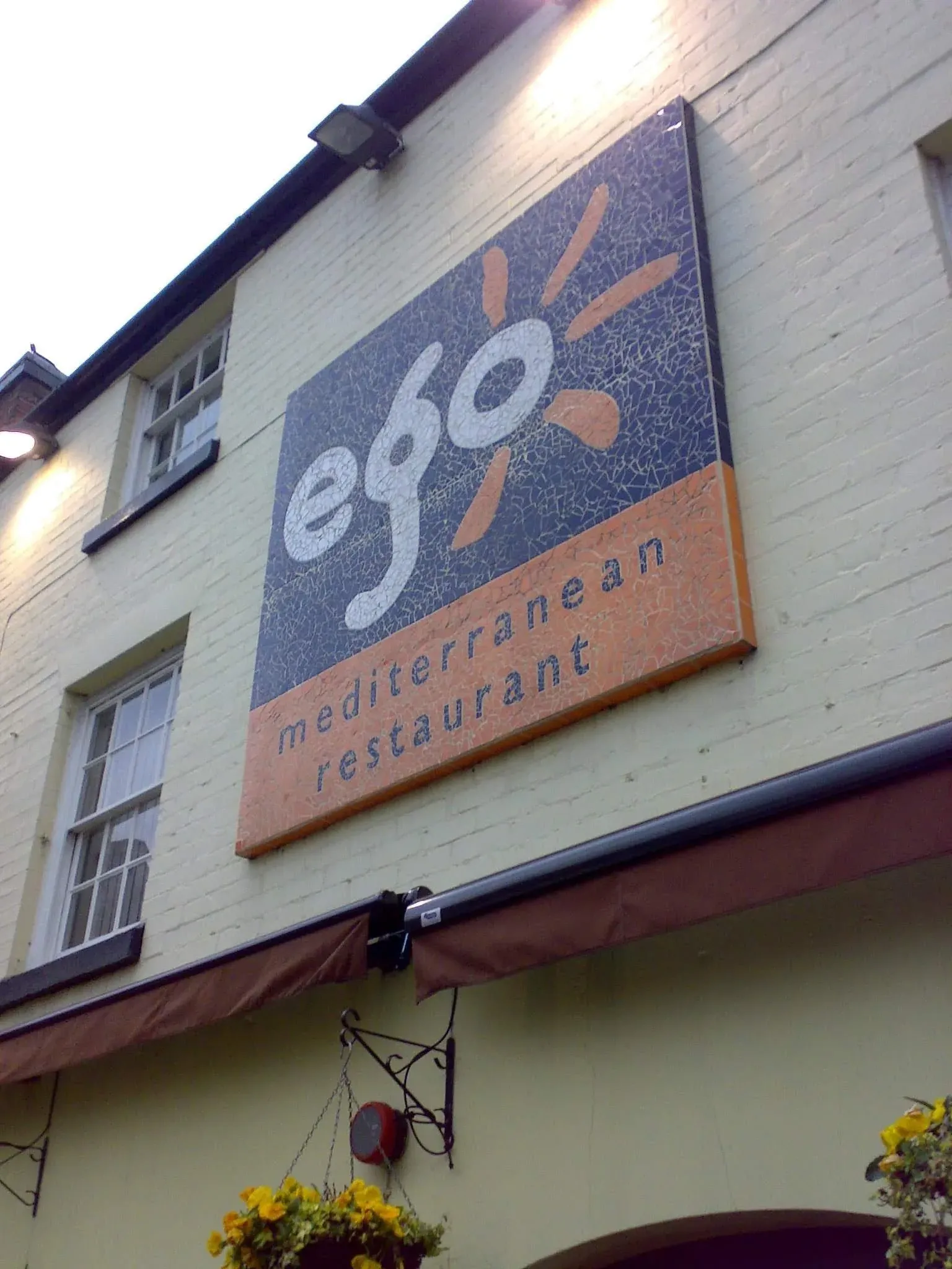 Eggstasy Mediterranean restaurant sign on white brick building wall