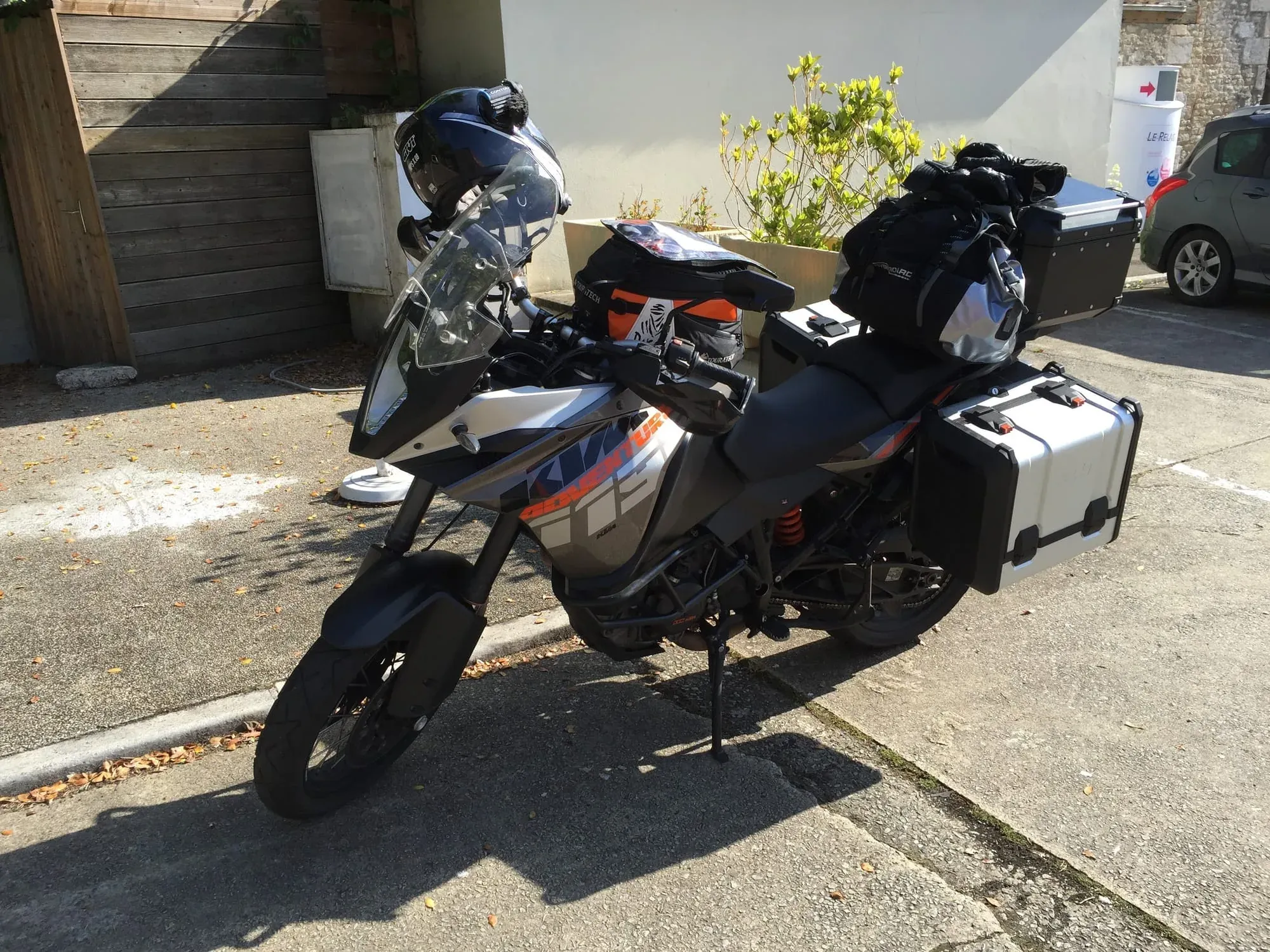 Three motorcycles with white saddlebags parked on residential street with helmets