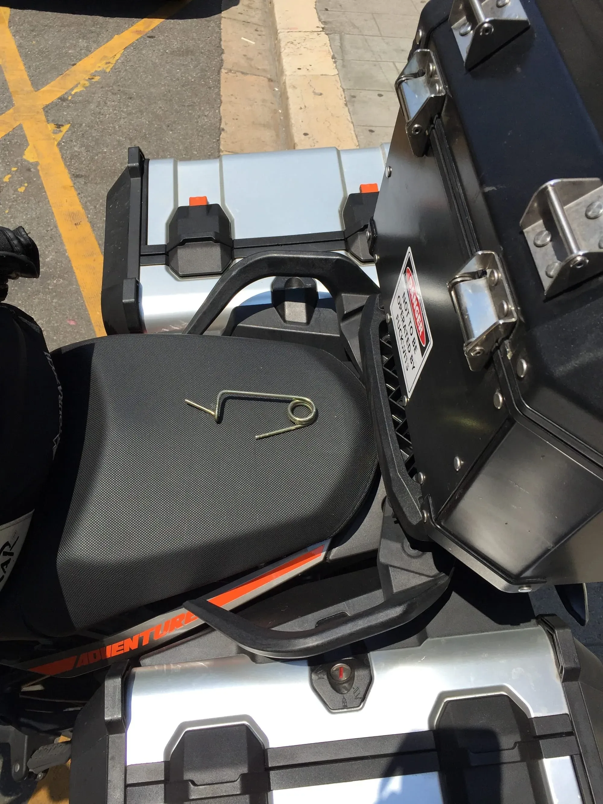 Top-down view of motorcycle with black and orange saddlebags parked on street