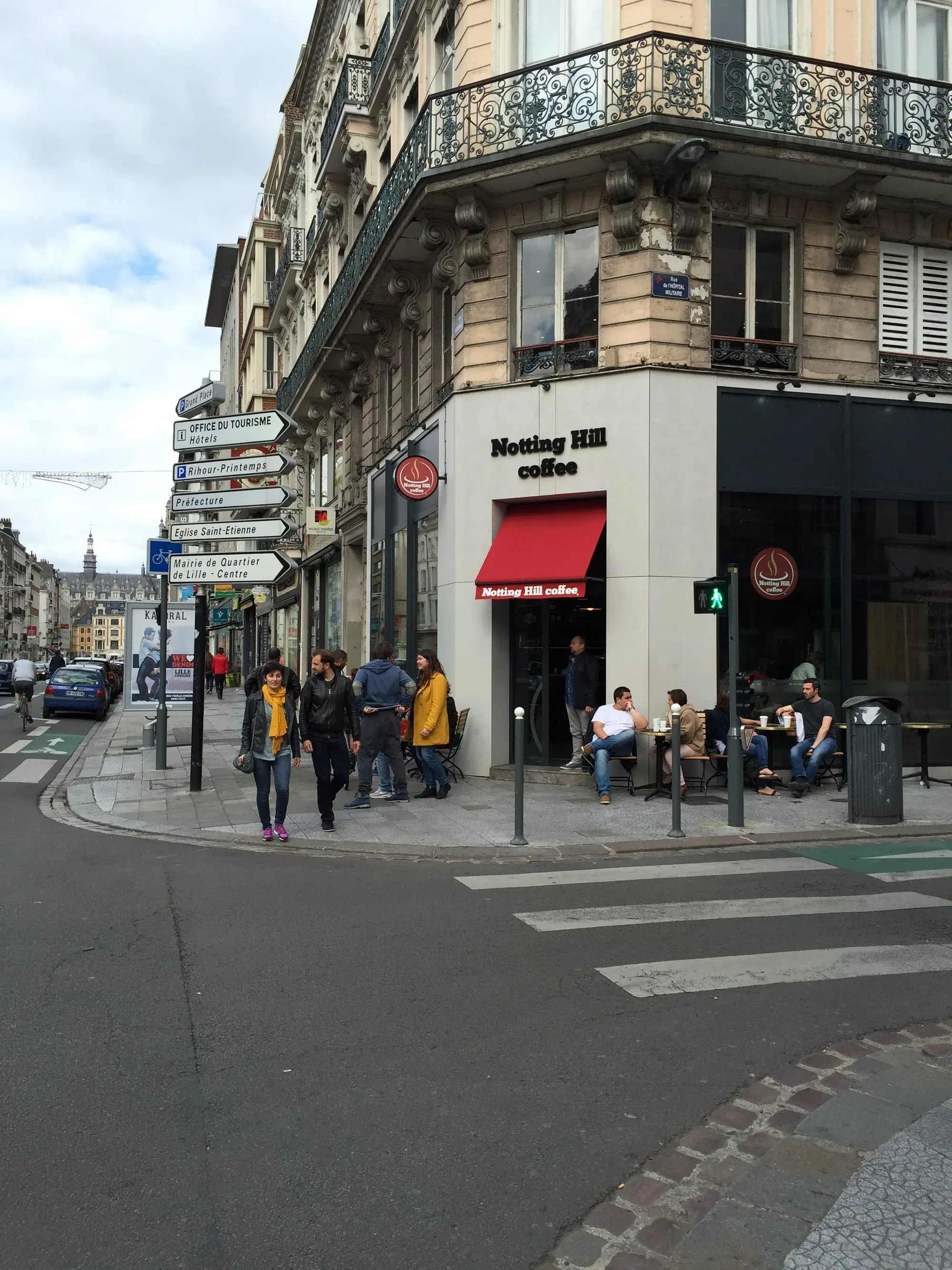 Notting Hill Coffee shop storefront on Parisian street corner with pedestrians