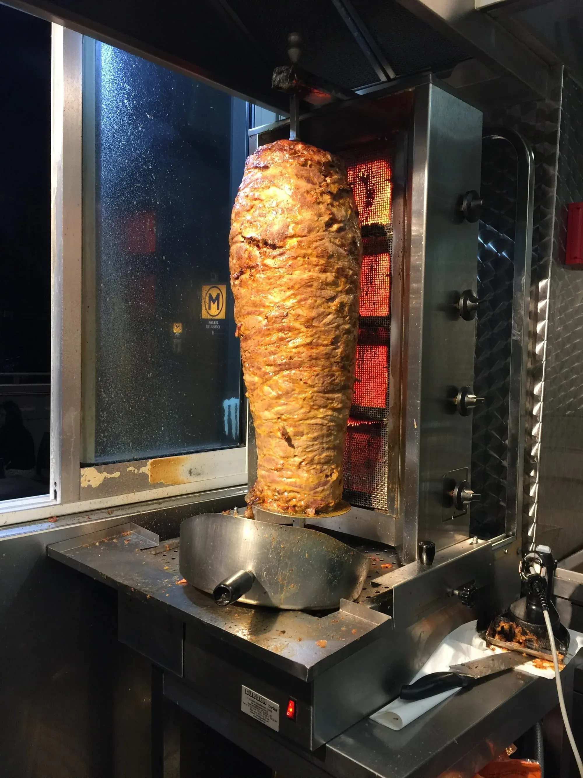 Rotisserie kebab meat cooking on vertical spit with infrared heating