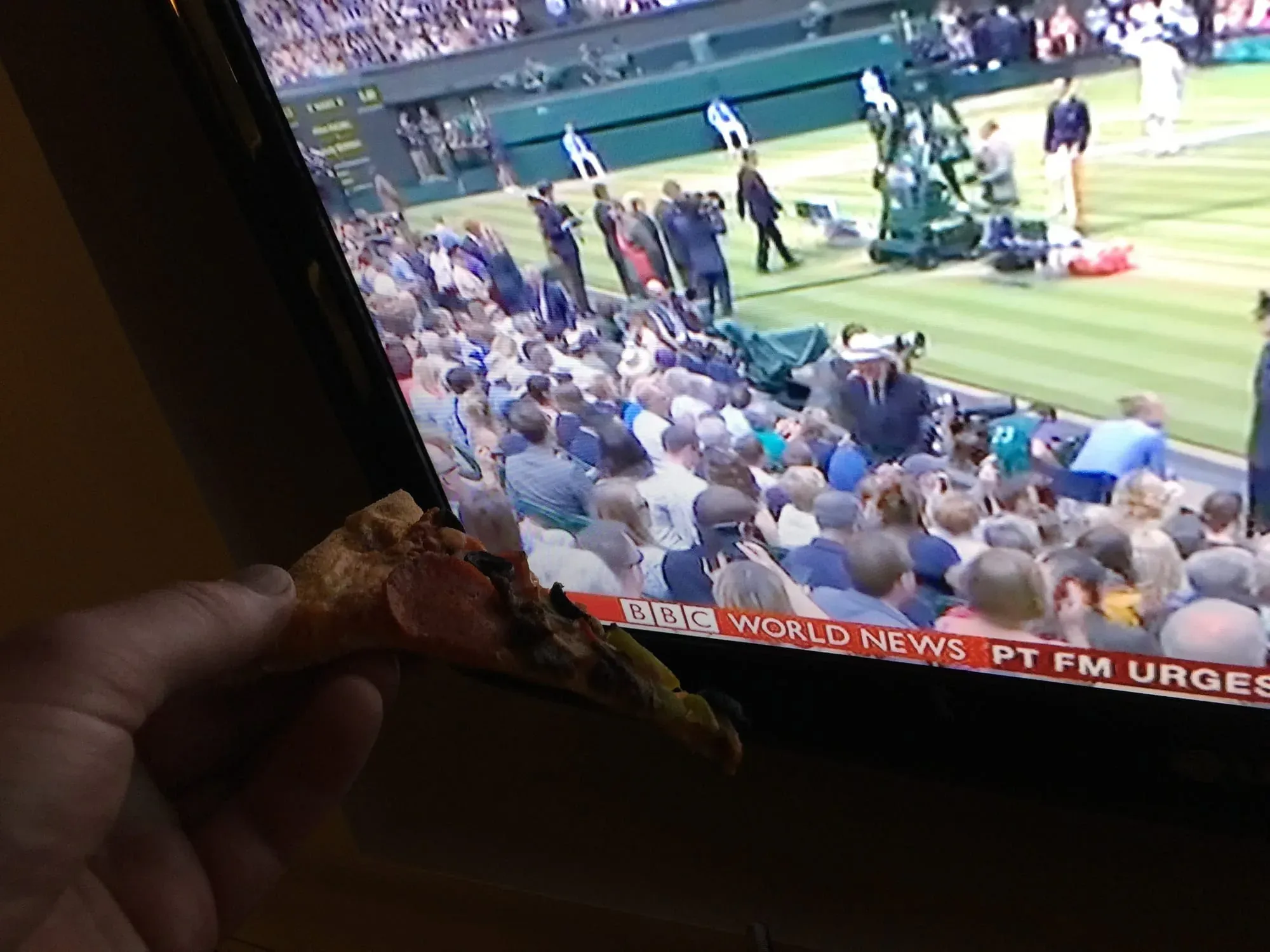 TV screen showing baseball stadium with crowd, BBC World News ticker visible
