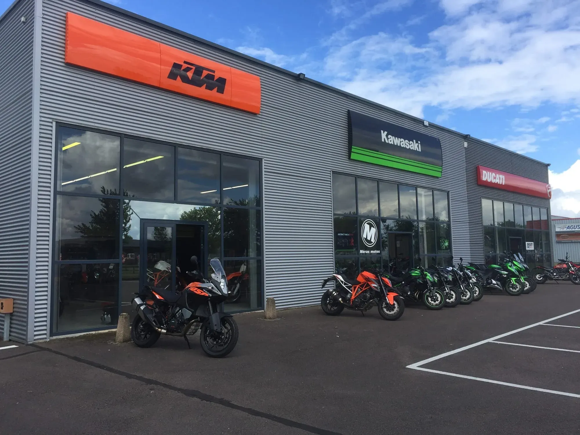KTM motorcycle dealership storefront with orange signage and bikes displayed