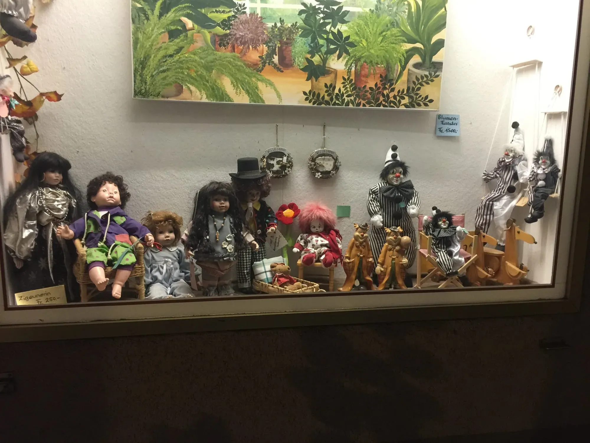 Display case with collection of decorative dolls in various costumes and styles