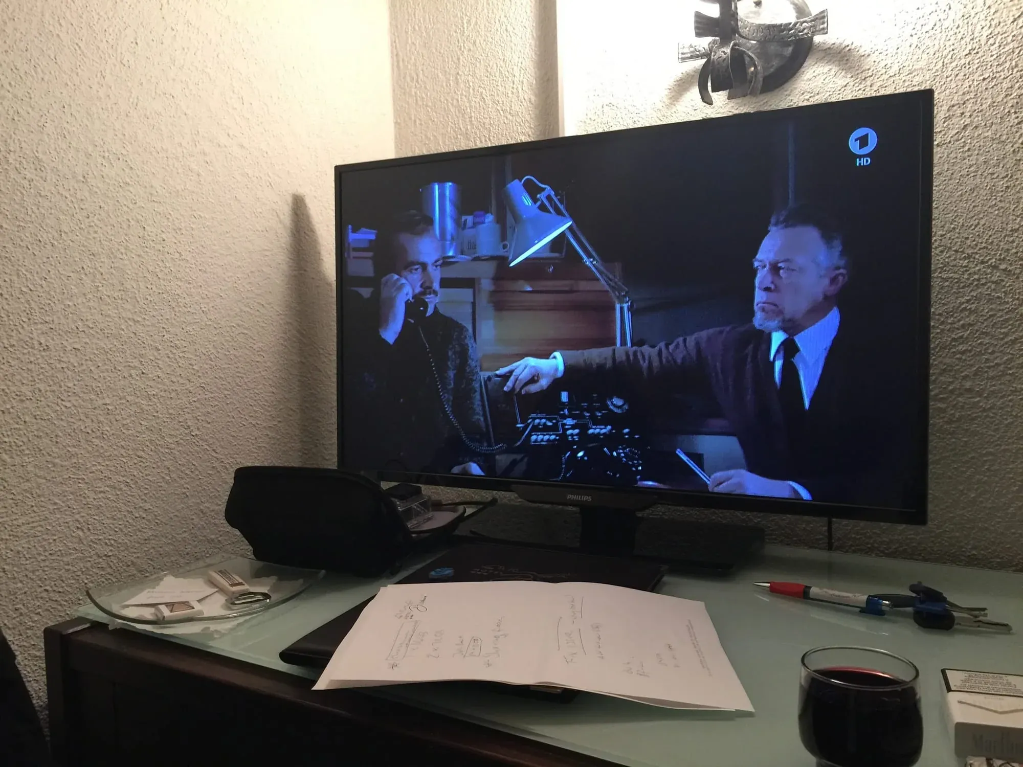 TV screen showing scene from noir film with two men in dark office setting