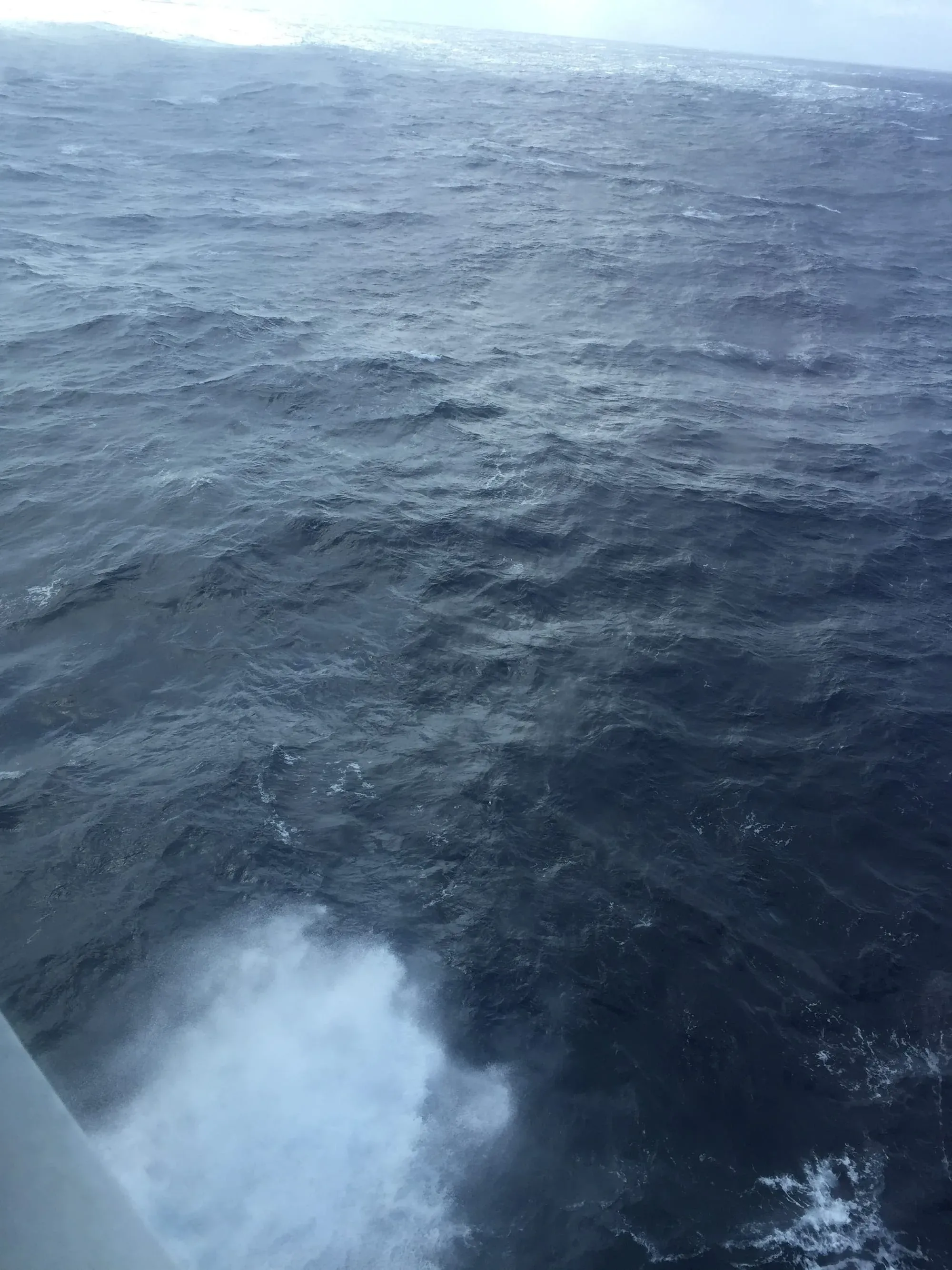 Rough ocean waves viewed from ship with whitecaps and spray