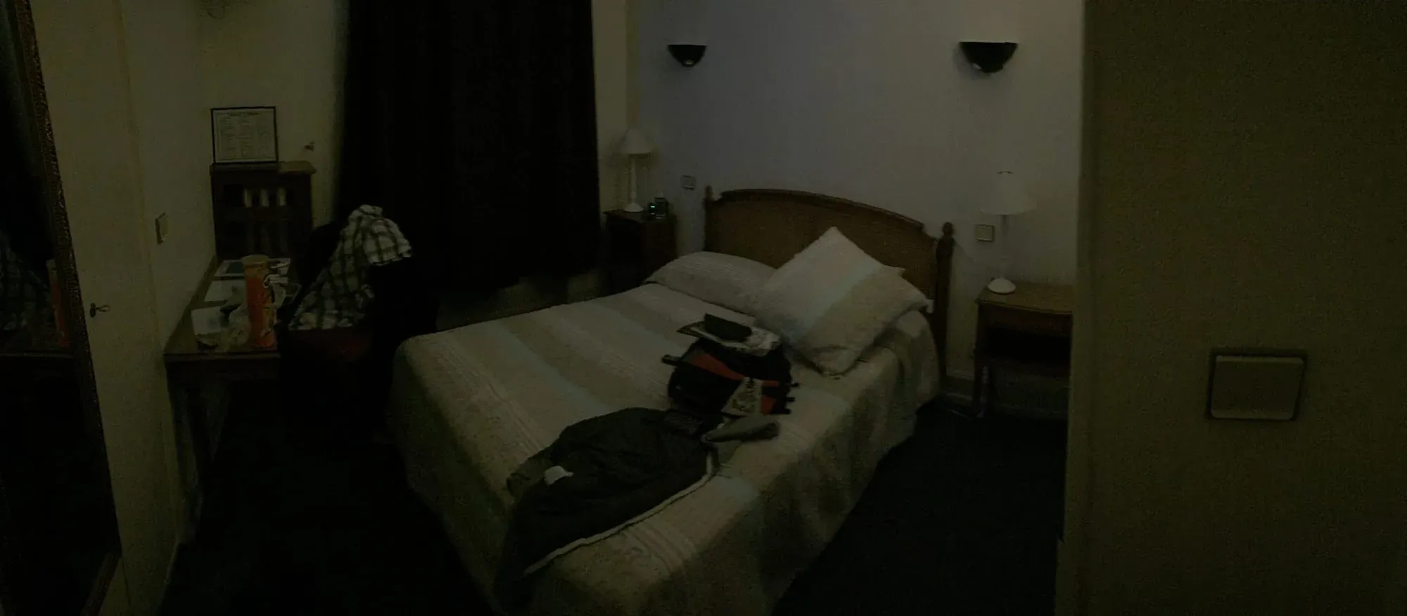 Hotel bedroom at night with bed and basic furnishings