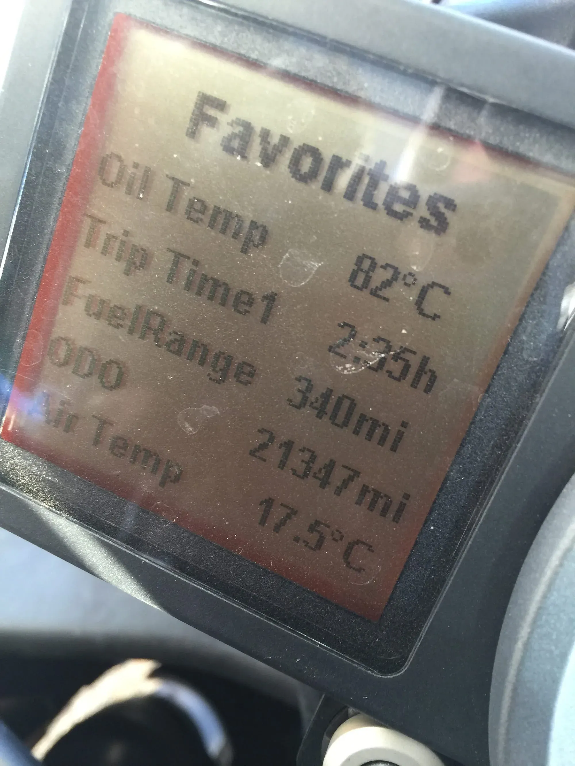 Motorcycle dash showing oil temp 82°C and fuel range 340mi