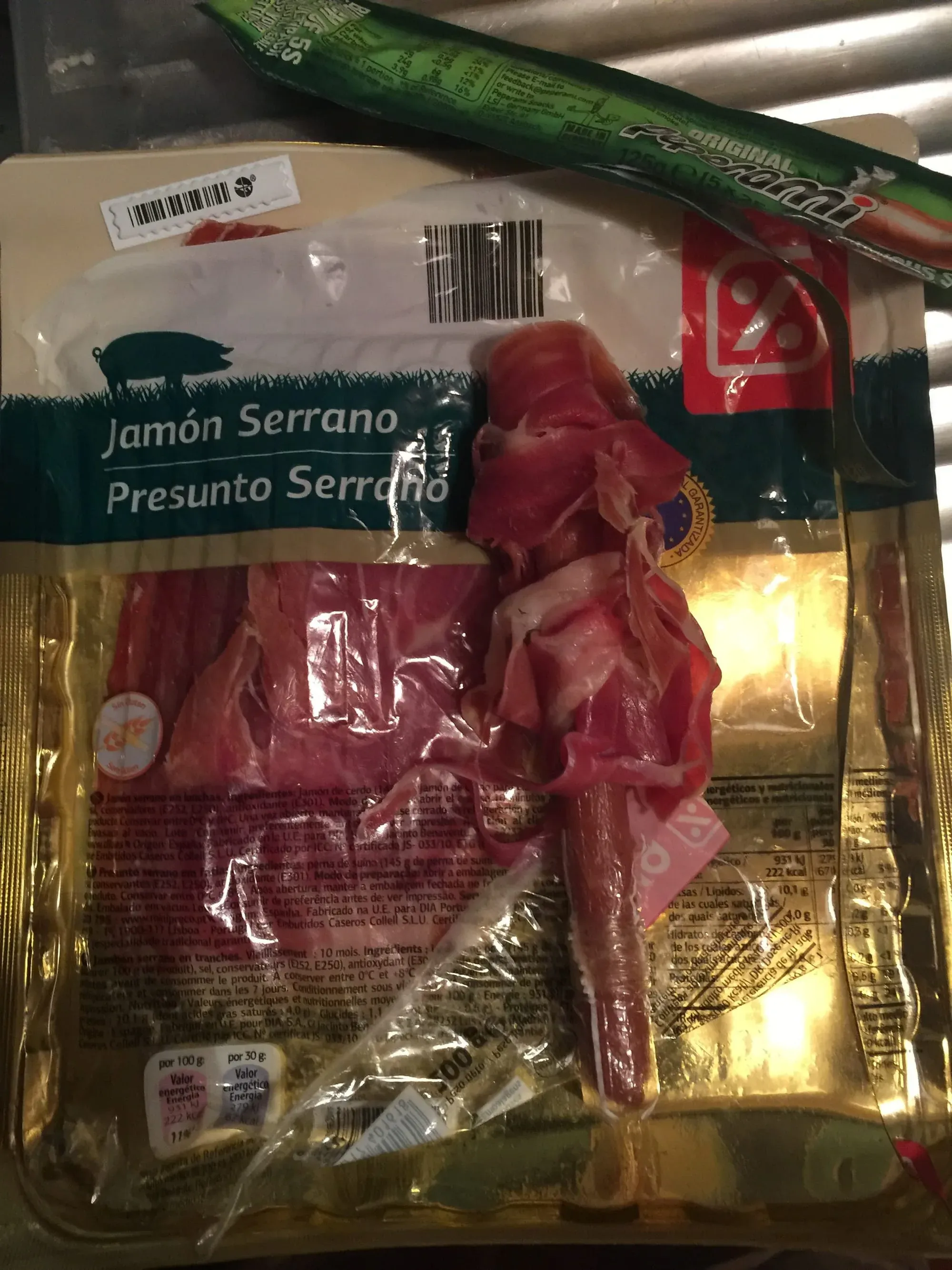 Package of Jamón Serrano Spanish cured ham with red ribbon bow on store shelf