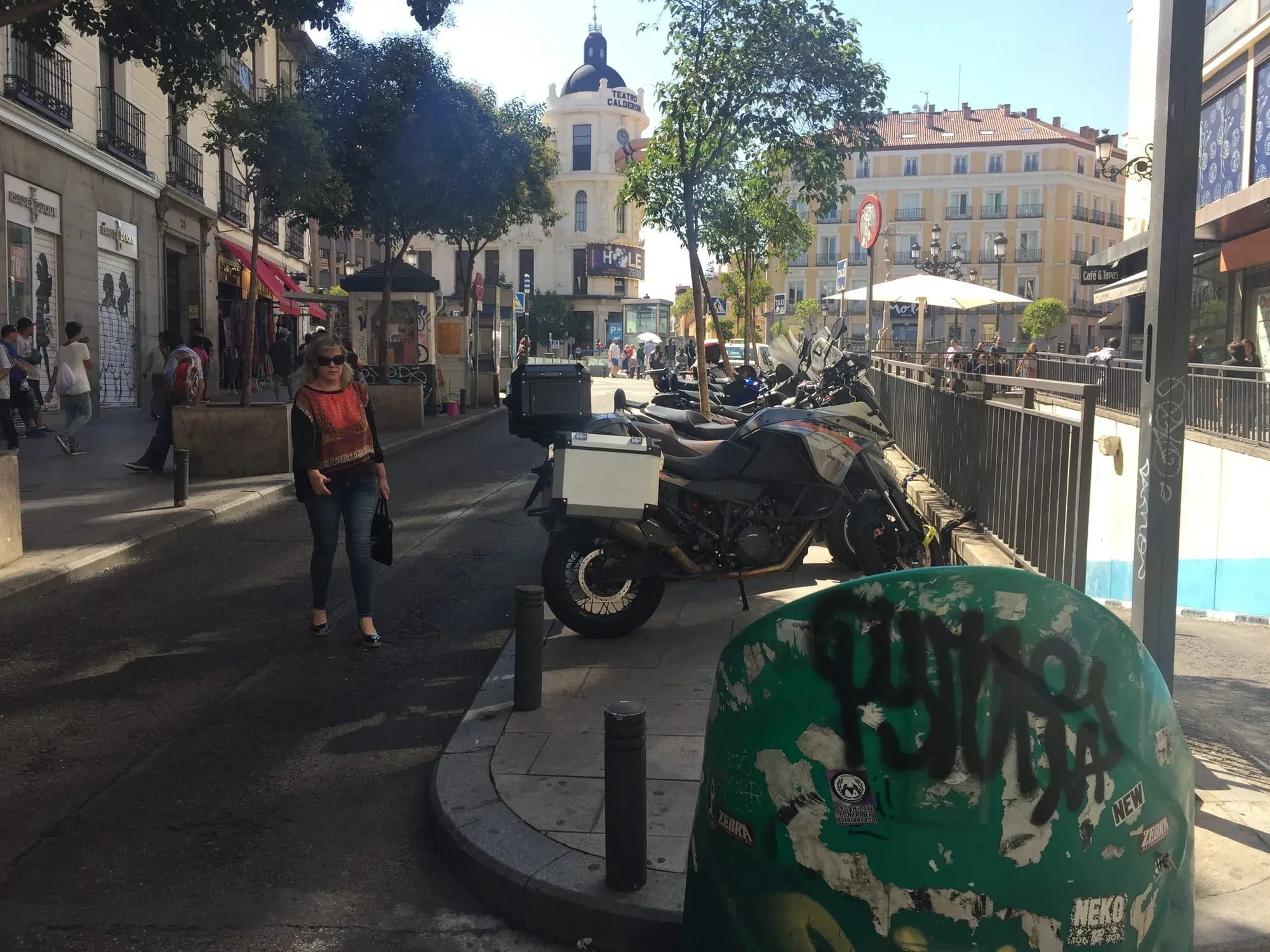 Sunny European street scene with motorcycles parked, historic buildings and cathedral dome