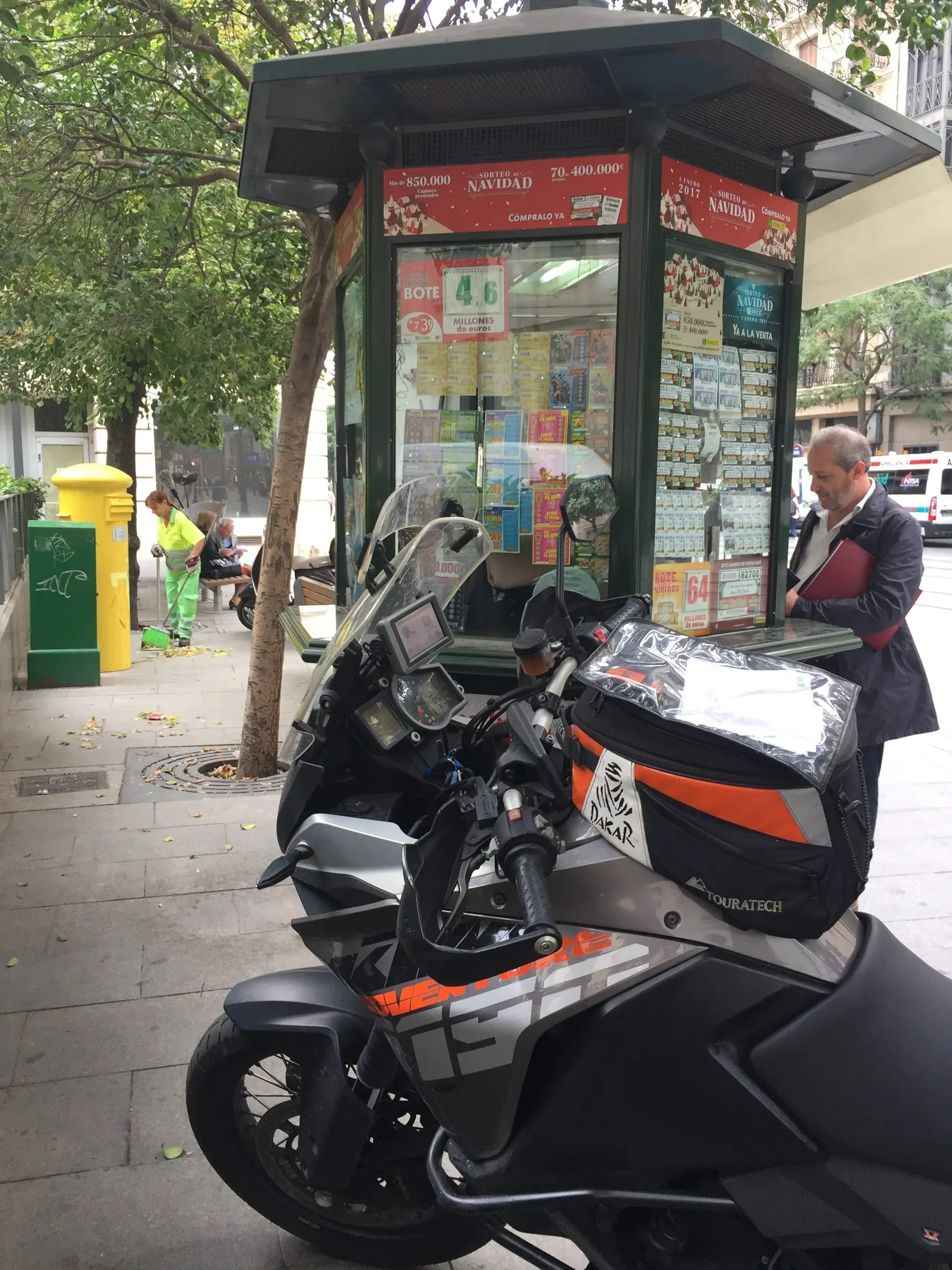 KTM motorcycle with topbox at lottery ticket kiosk on urban street