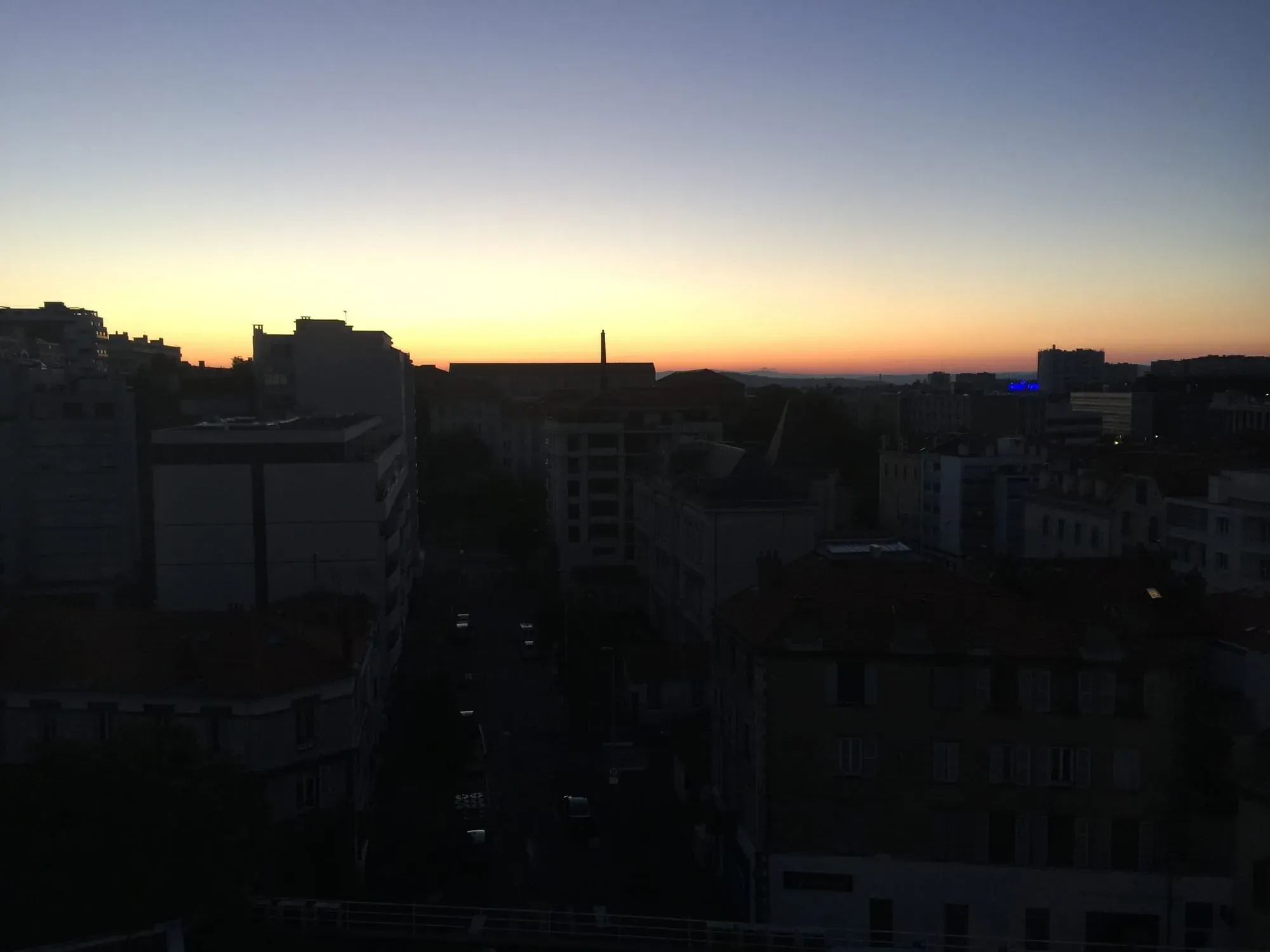 Urban rooftop sunset view with Washington DC monument silhouette in distance