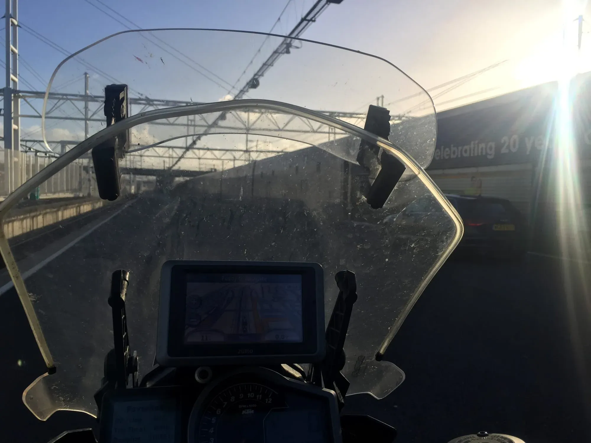 Motorcycle windshield view of highway with power transmission lines overhead