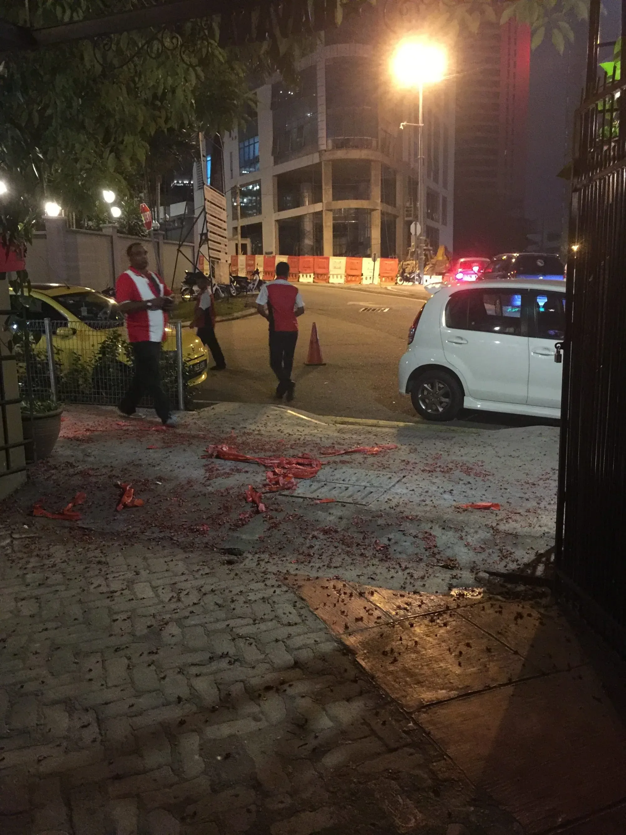 Street scene at night with emergency vehicles and workers in safety vests