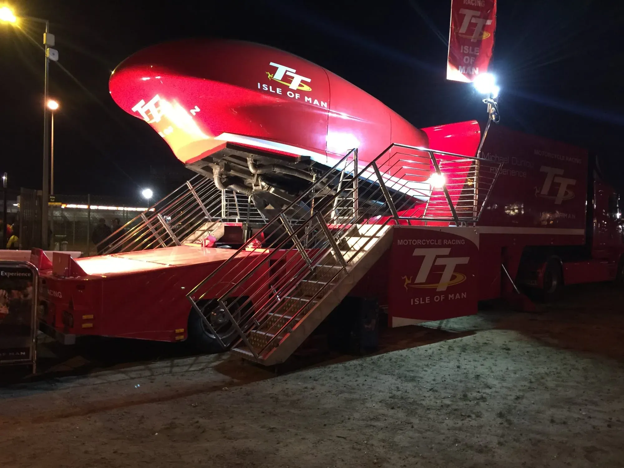 Red TT Isle of Man motorcycle racing exhibition structure lit up at night