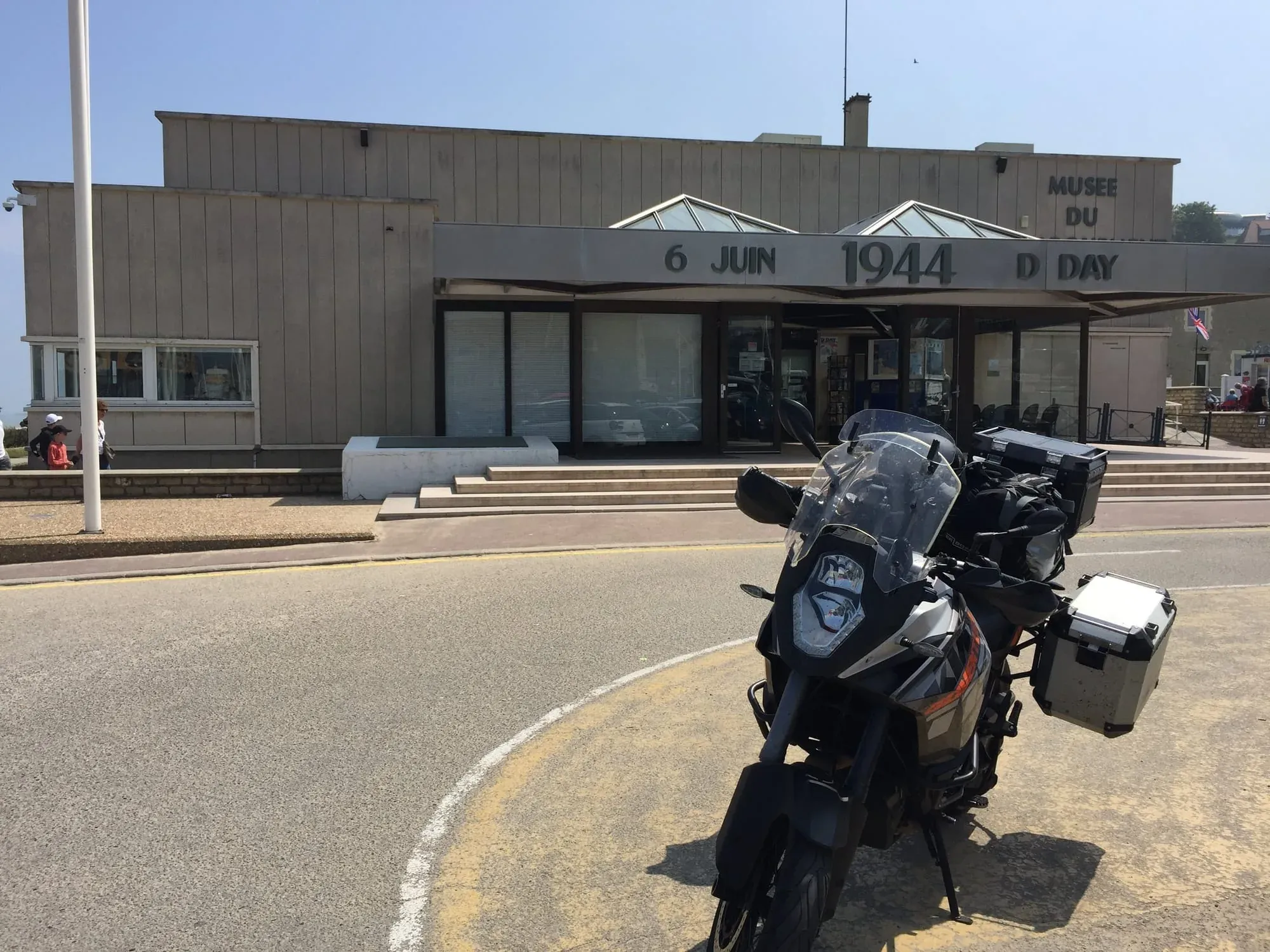 Motorcycle parked in front of D-Day Museum building with signage