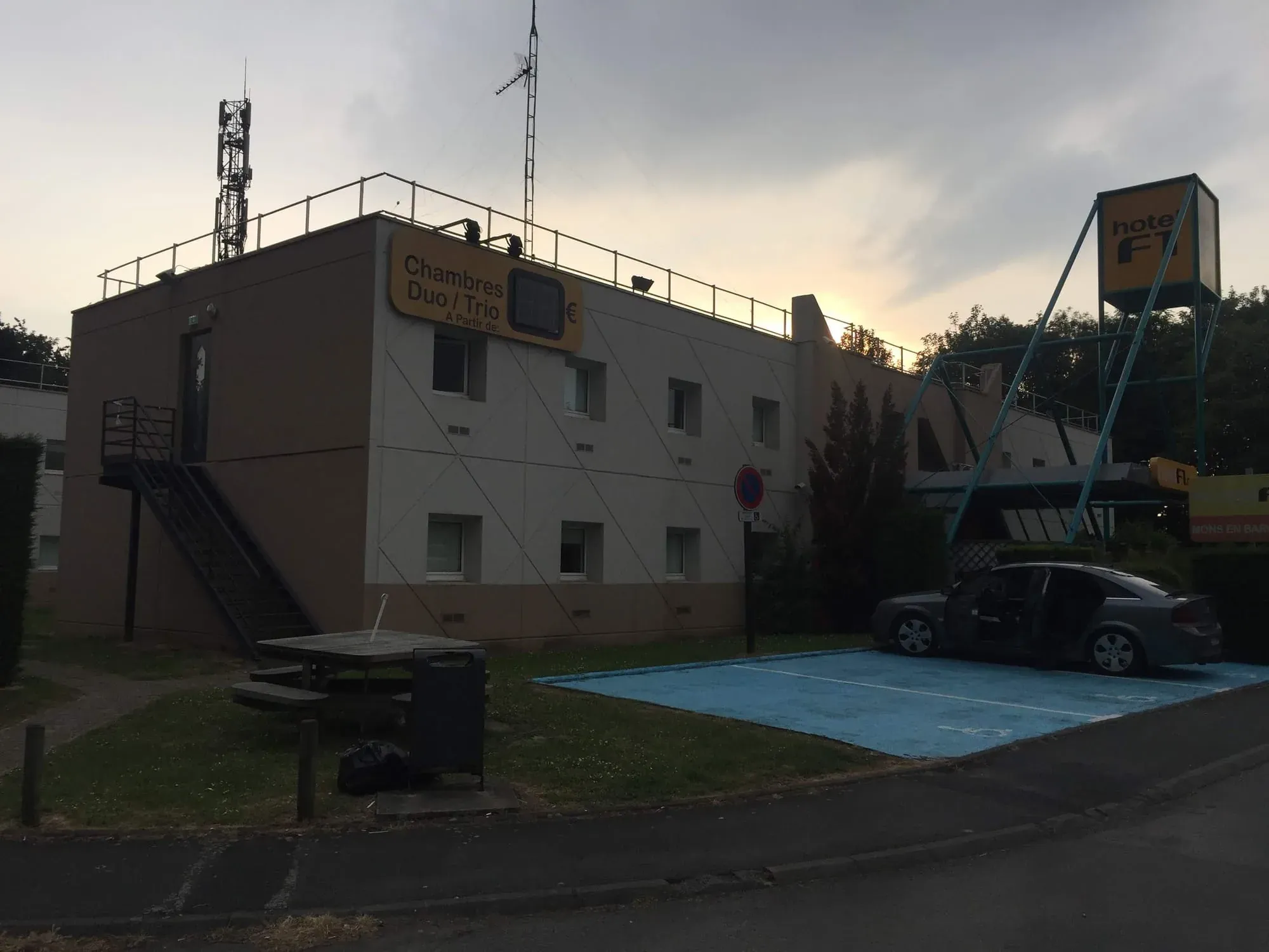 Concrete building labeled Chambres Duo with antenna and water tank