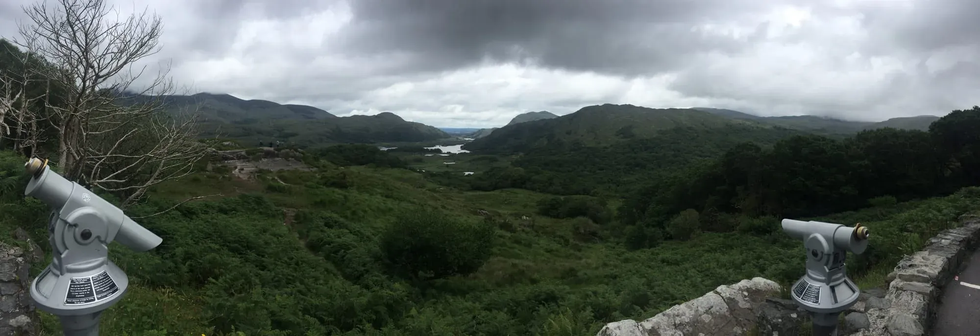 Panoramic landscape view of green valleys, mountains and lakes with viewing telescopes