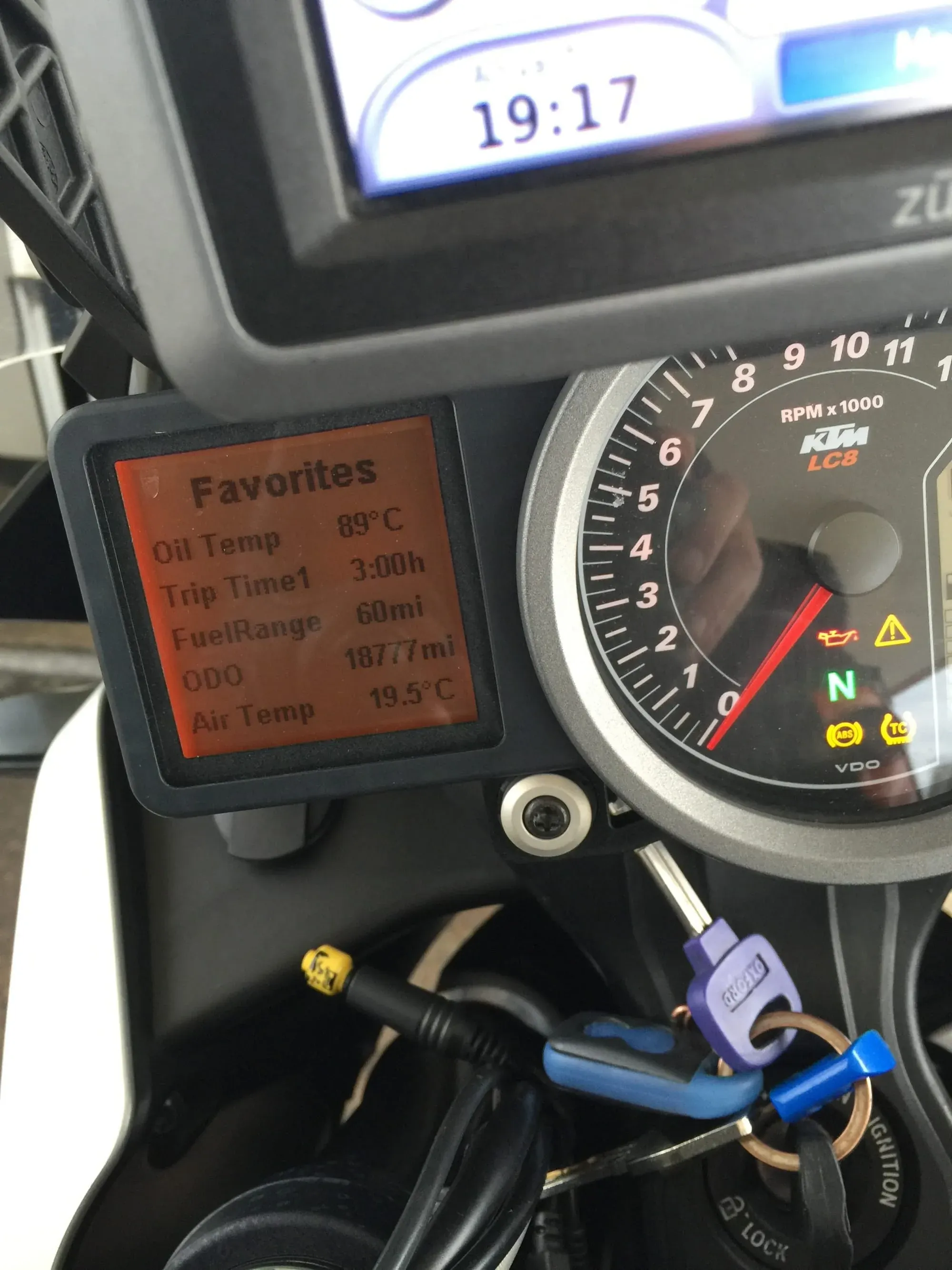 KTM motorcycle dashboard display showing oil temp 89°C, trip time 3:00h, fuel range 60mi