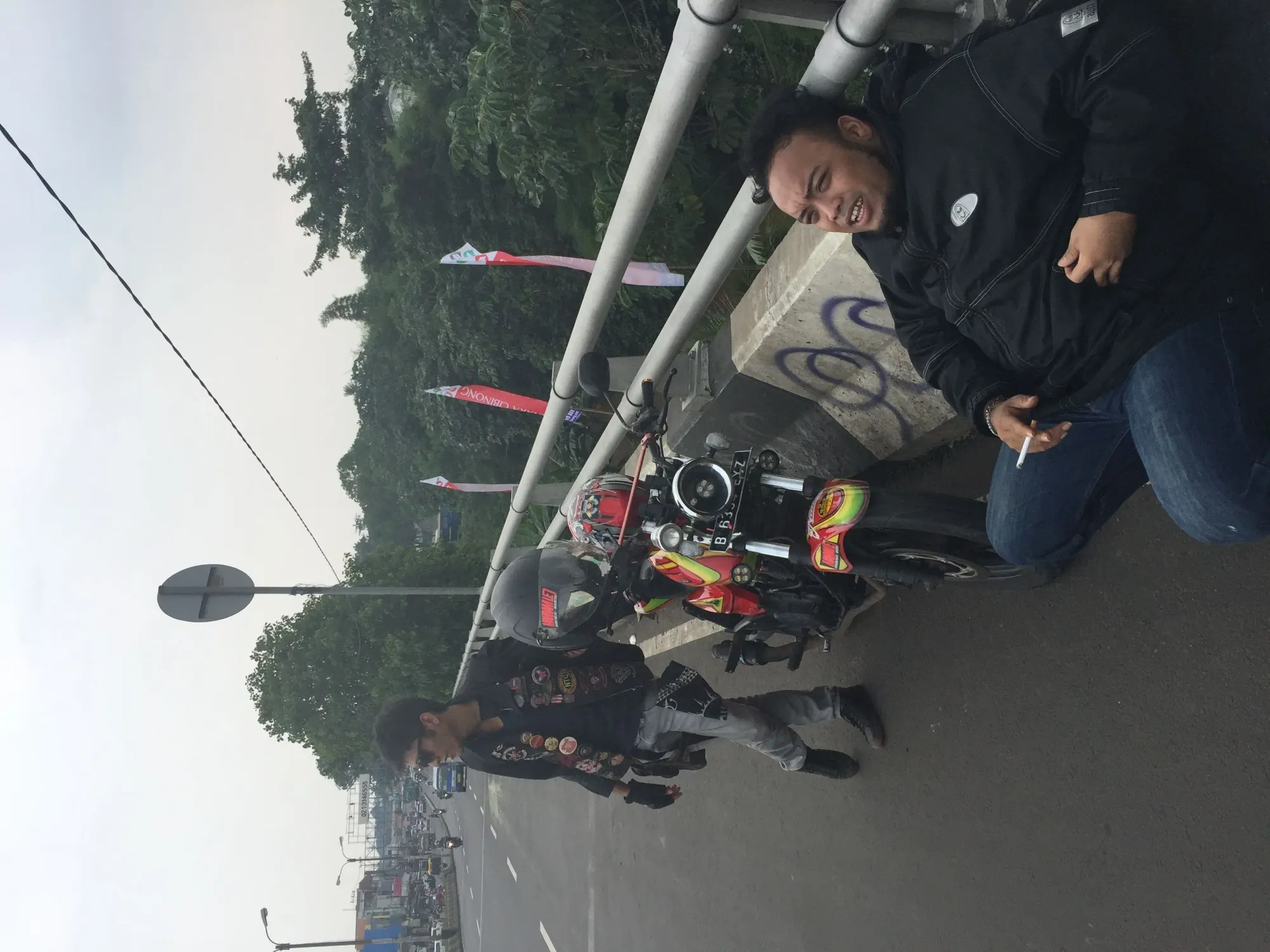 Two men with customized motorcycle at Cirimekar overpass, West Java