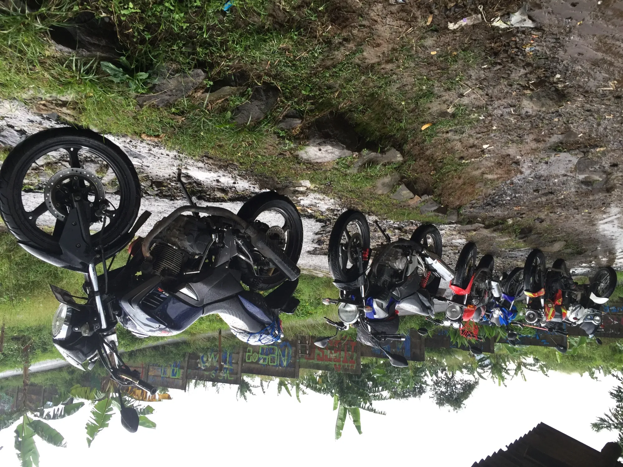Motorcycles parked in muddy field, Sukawangi
