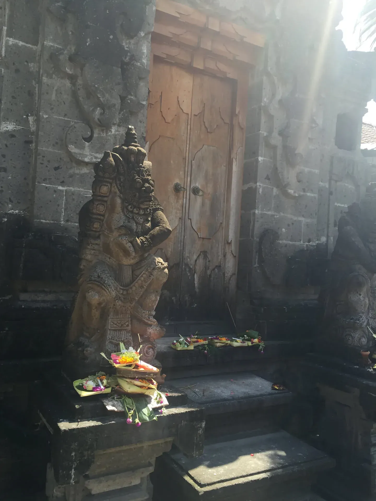Ornate stone deity statue in Seminyak temple courtyard