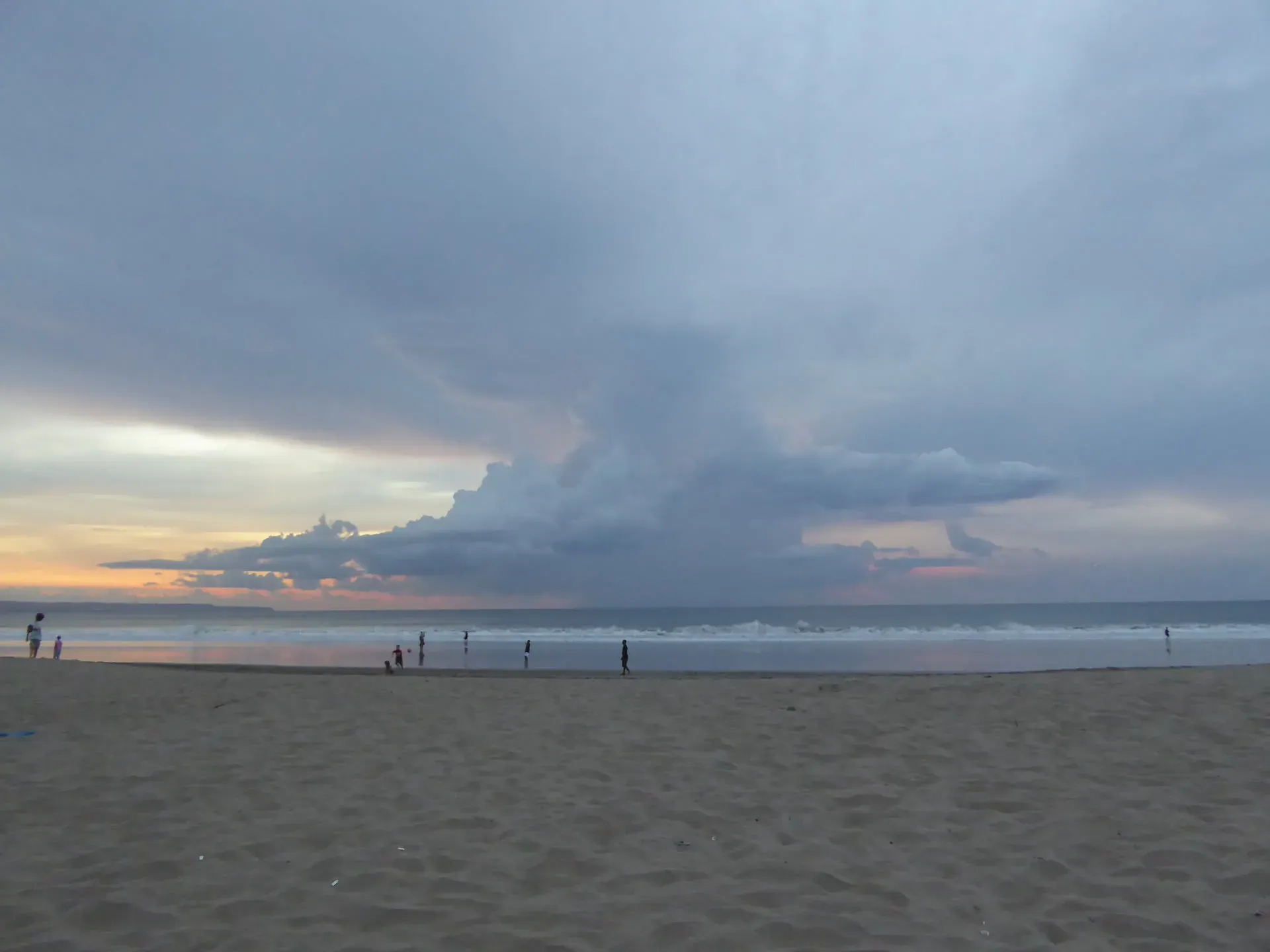 Dramatic storm clouds over Legian beach at sunset