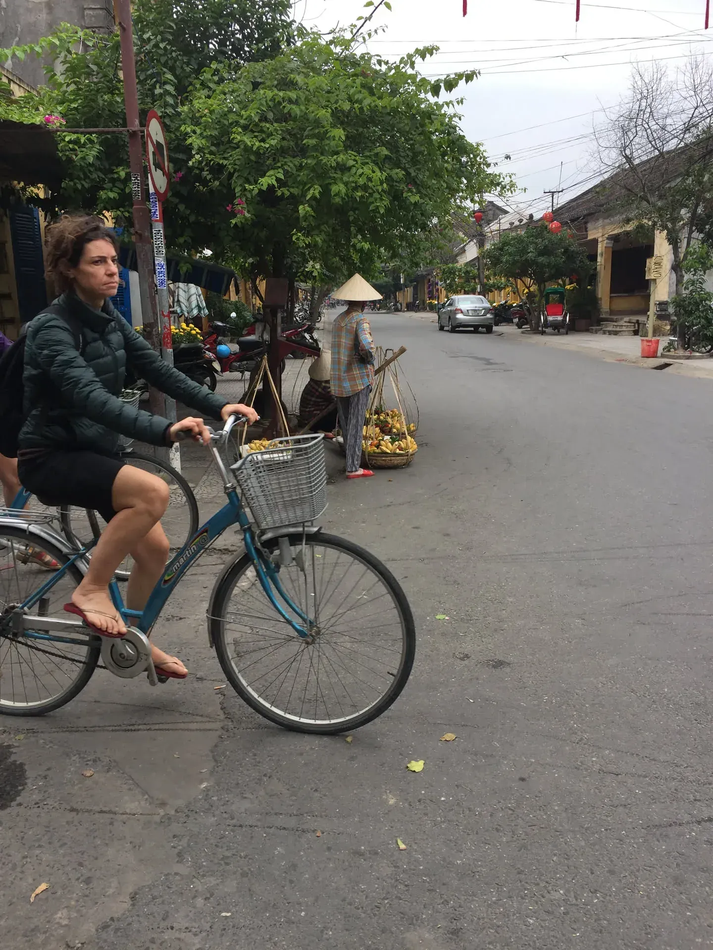Woman cycling through street in Sơn Phong village, Vietnam