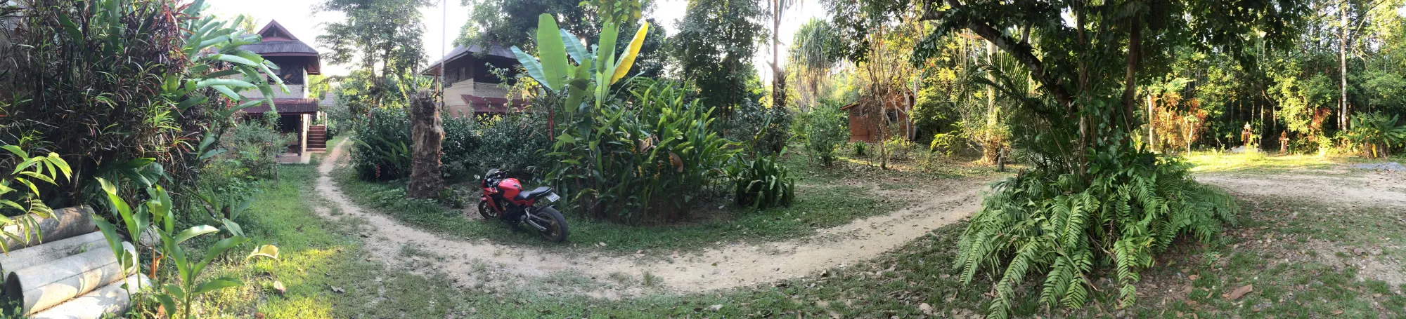 Red motorcycle parked in rural village, Surat Thani Province