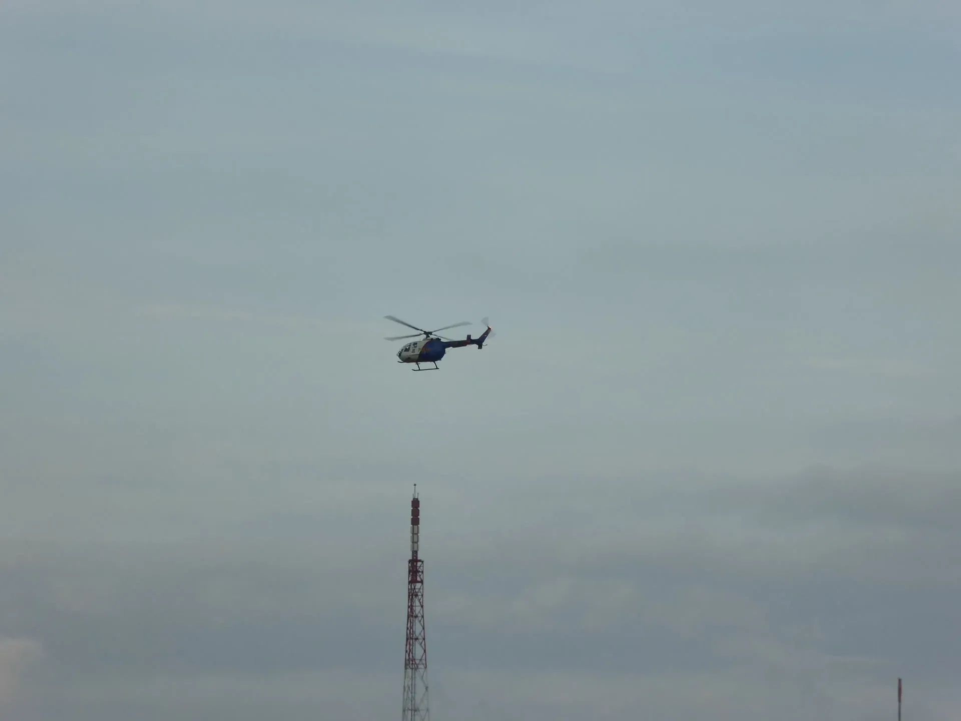 Helicopter flying above a telecommunications tower