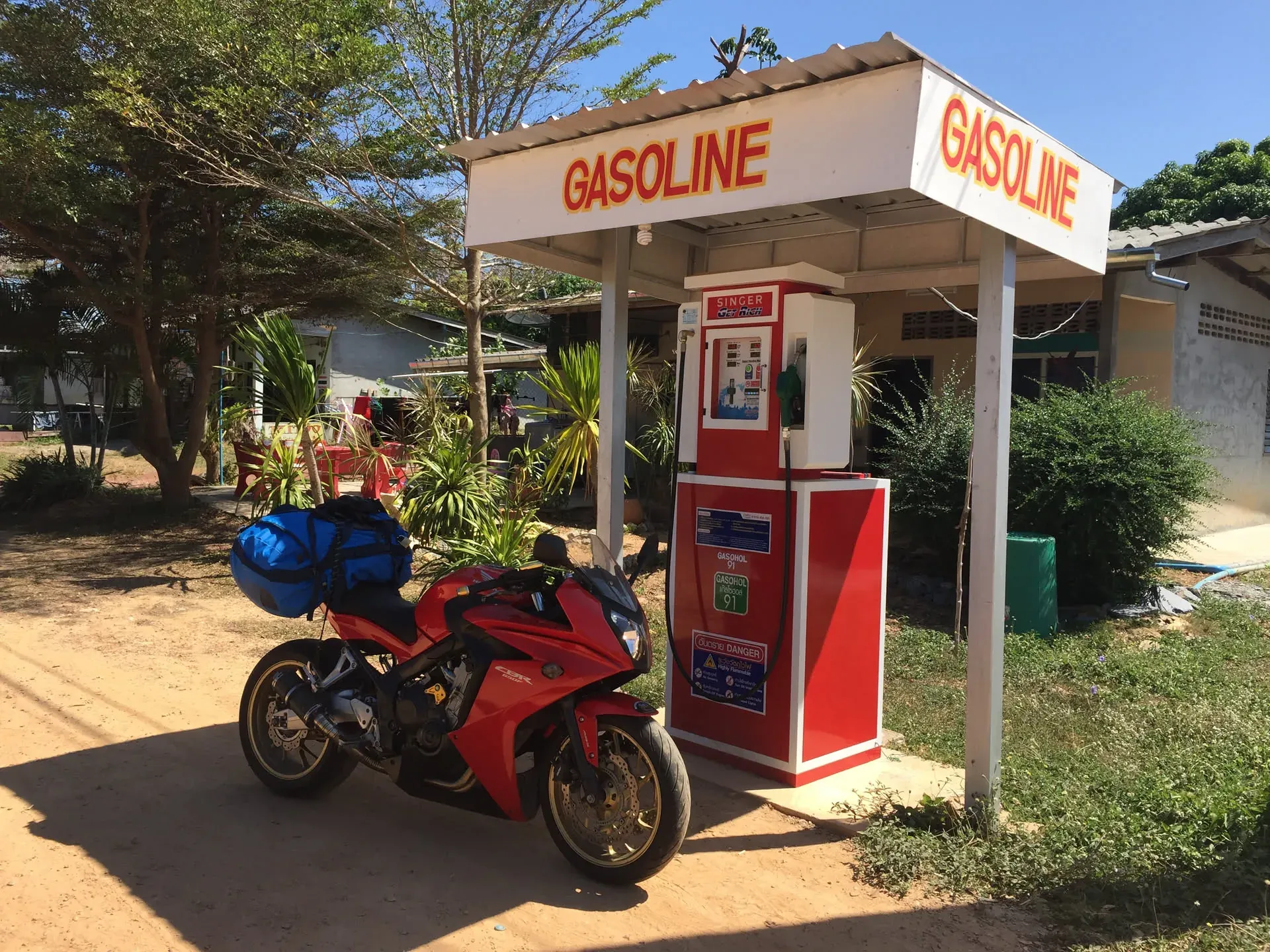 Red motorcycle at vintage gas pump, Saladan