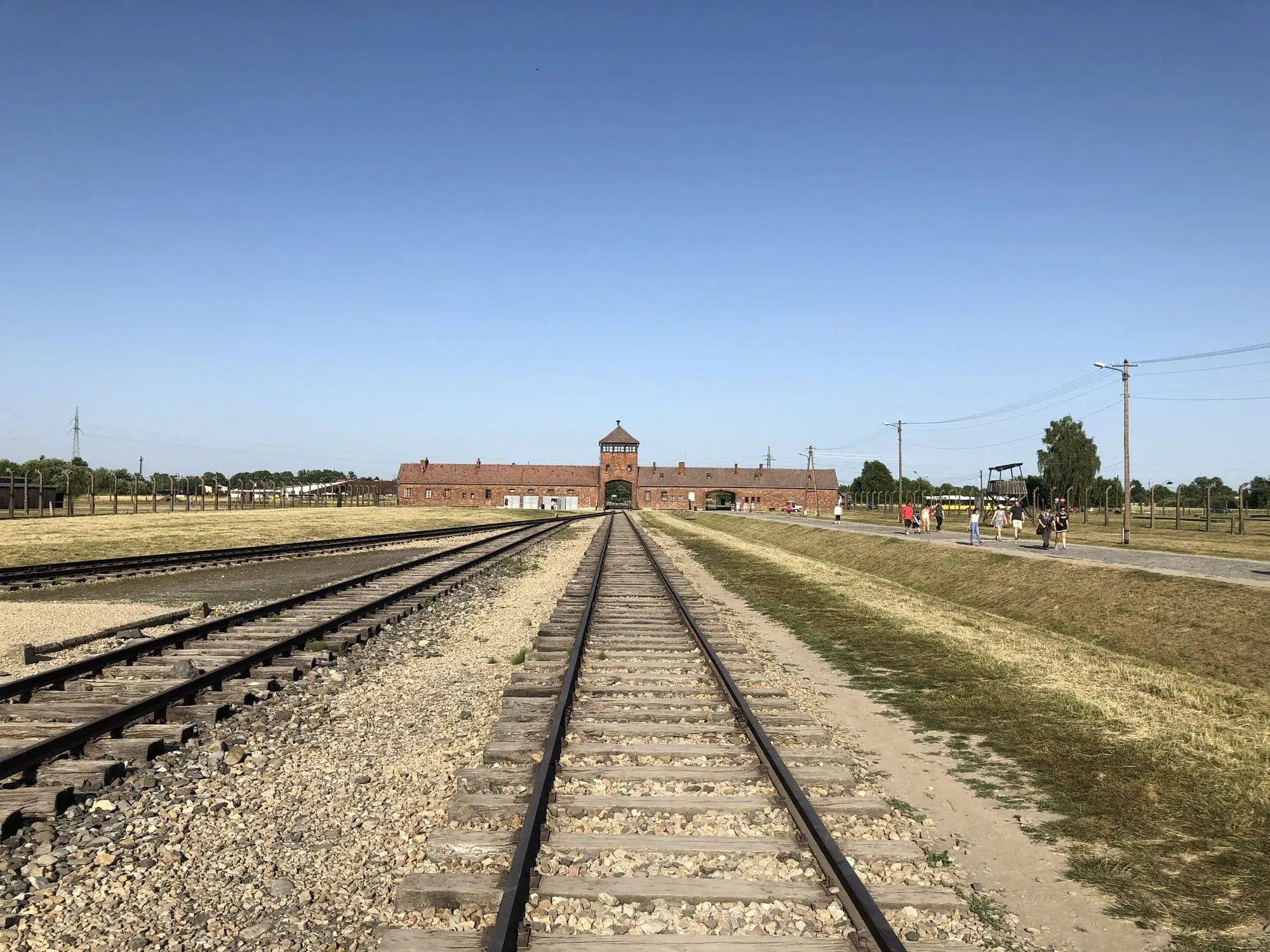 Railroad tracks leading to brick building with guard tower