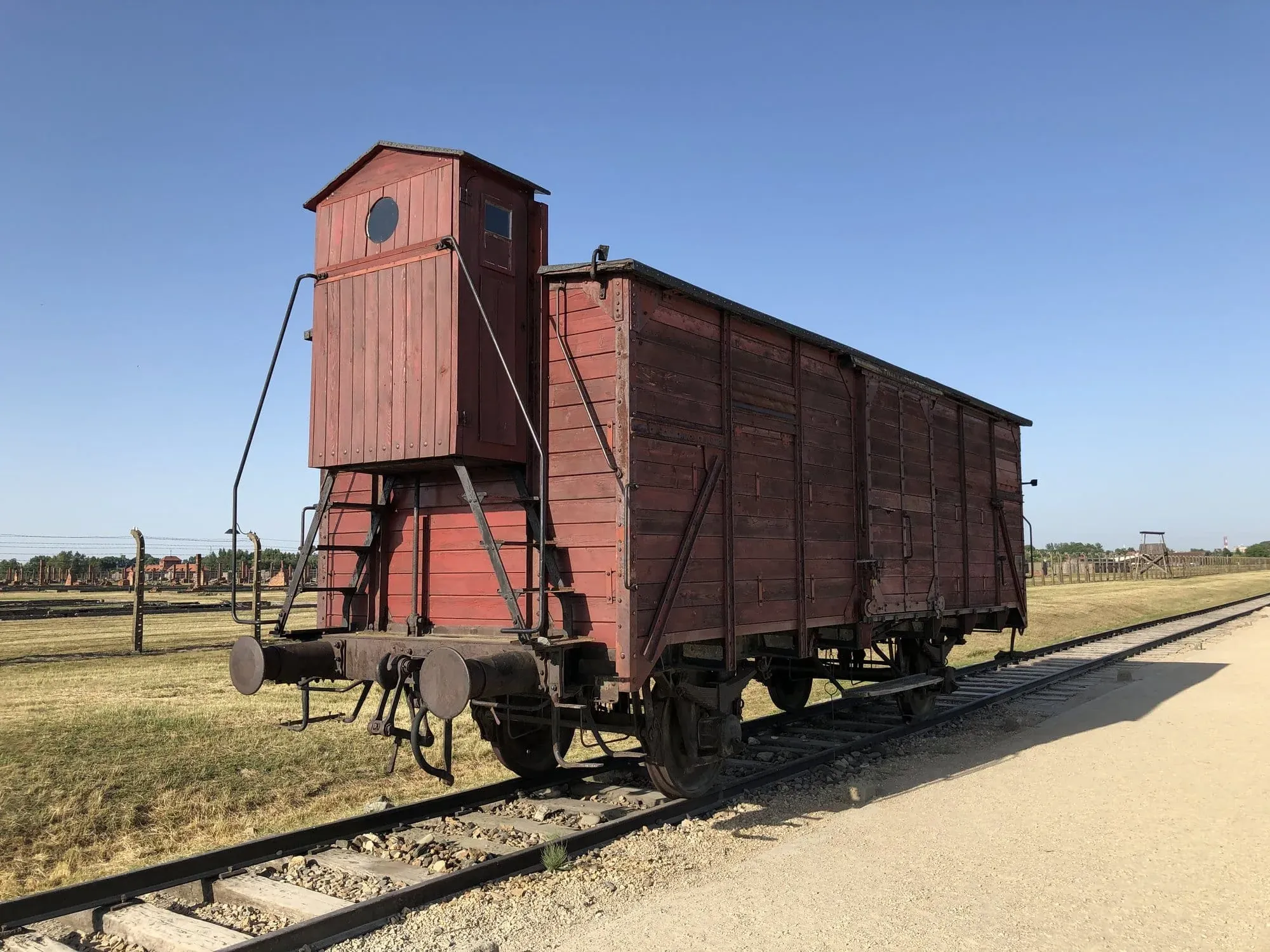 Vintage red railway freight car with water tower on tracks