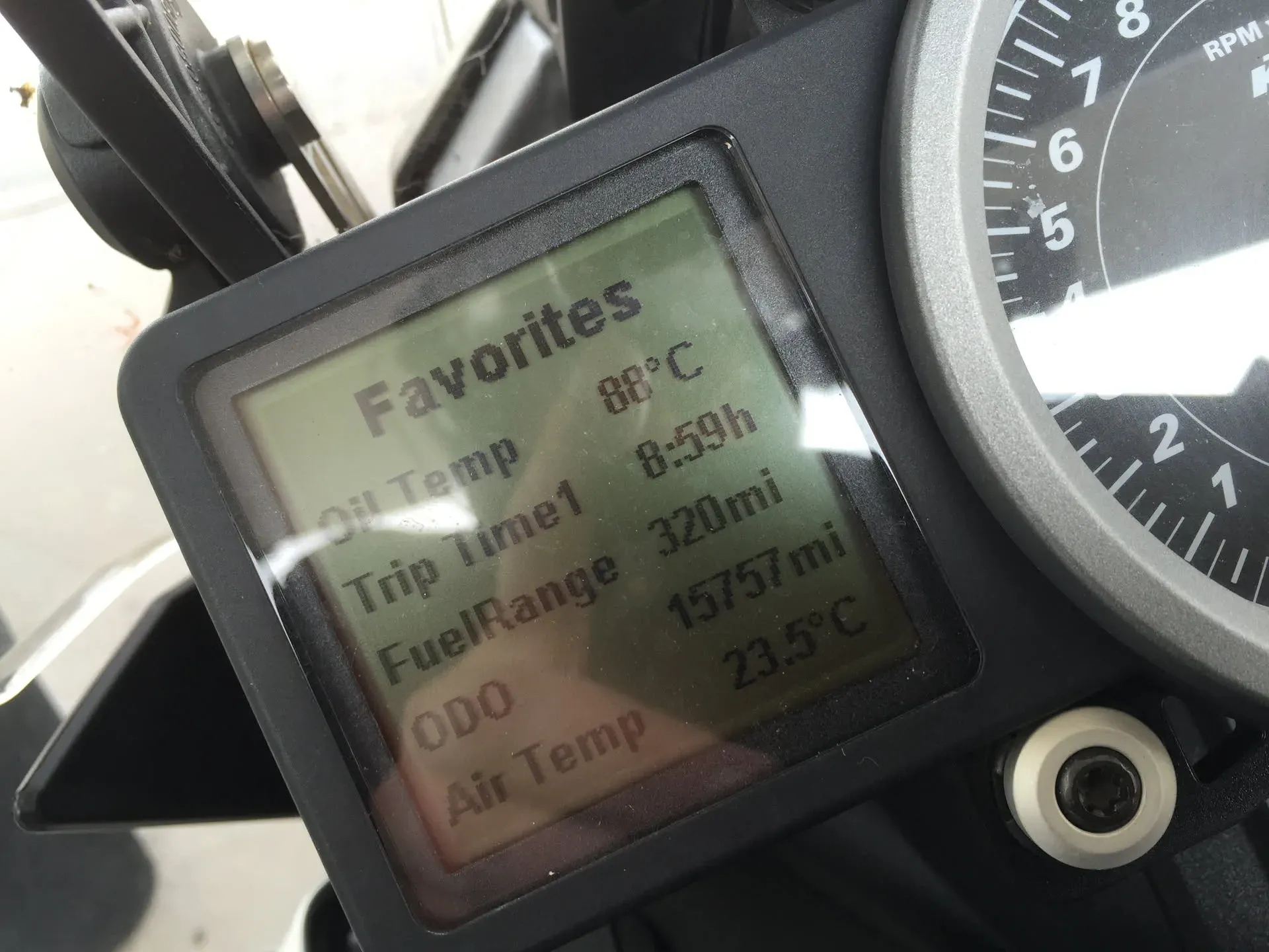 Motorcycle dashboard showing trip data at Burnenville, Liège