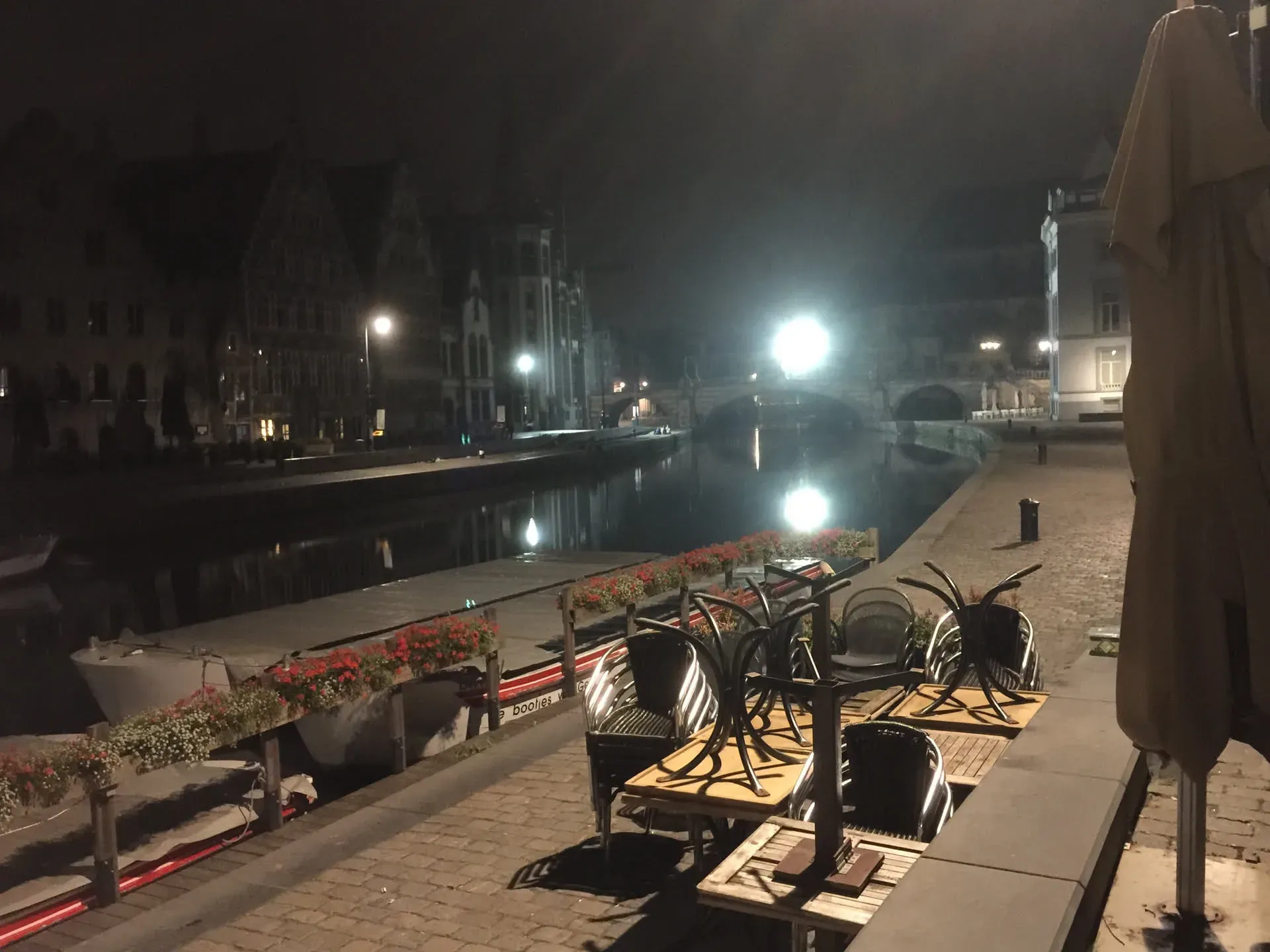 Waterfront café seating along Ghent canal at night