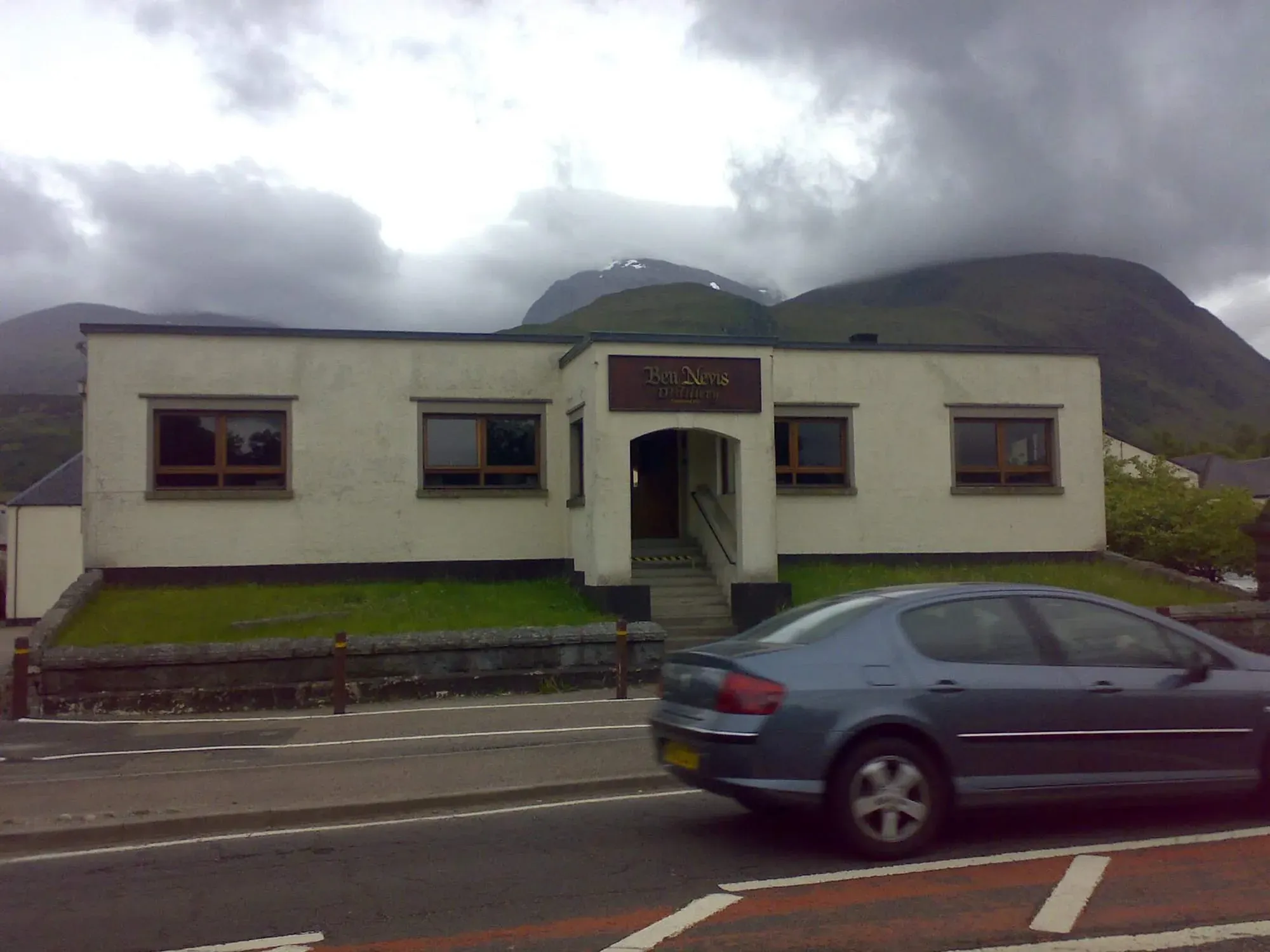 Bon Nevis Distillery visitor center building with mountains in background