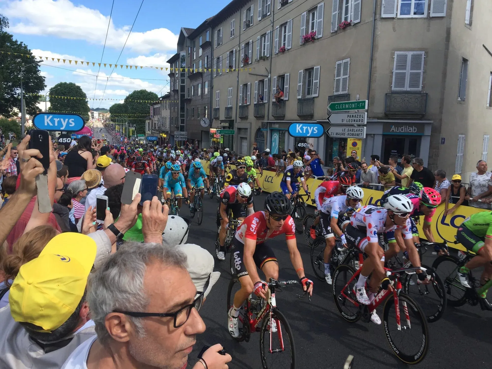 Tour de France cyclists riding through crowded French city street