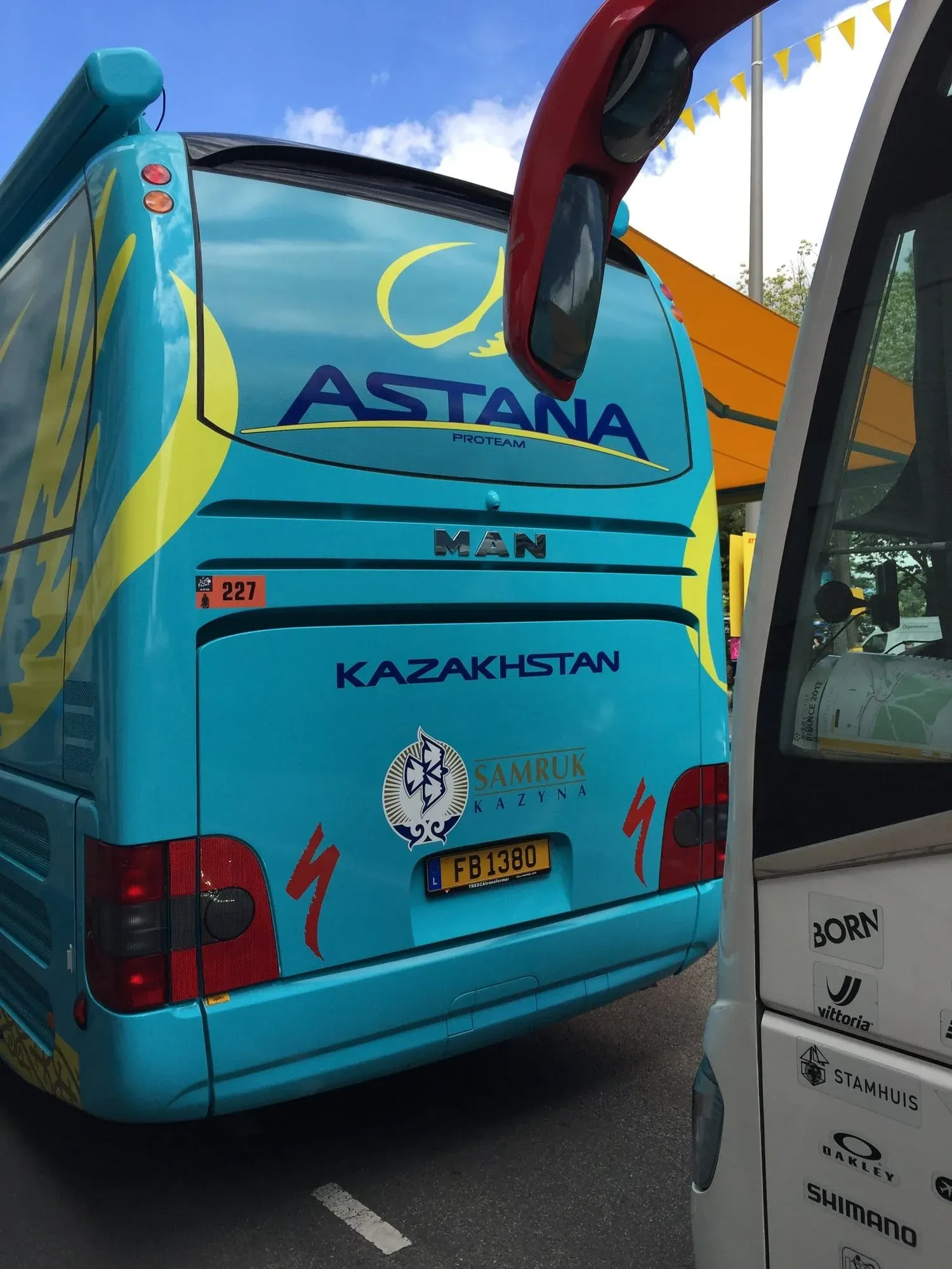 Turquoise Astana ProTeam bus parked at cycling event
