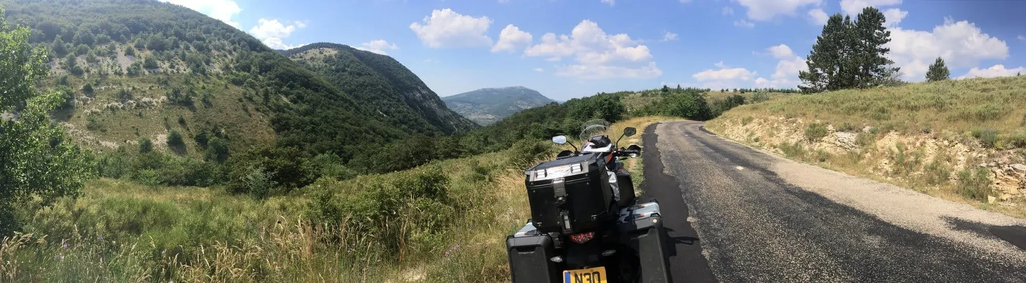 Motorcycle parked on mountain road with scenic valley views