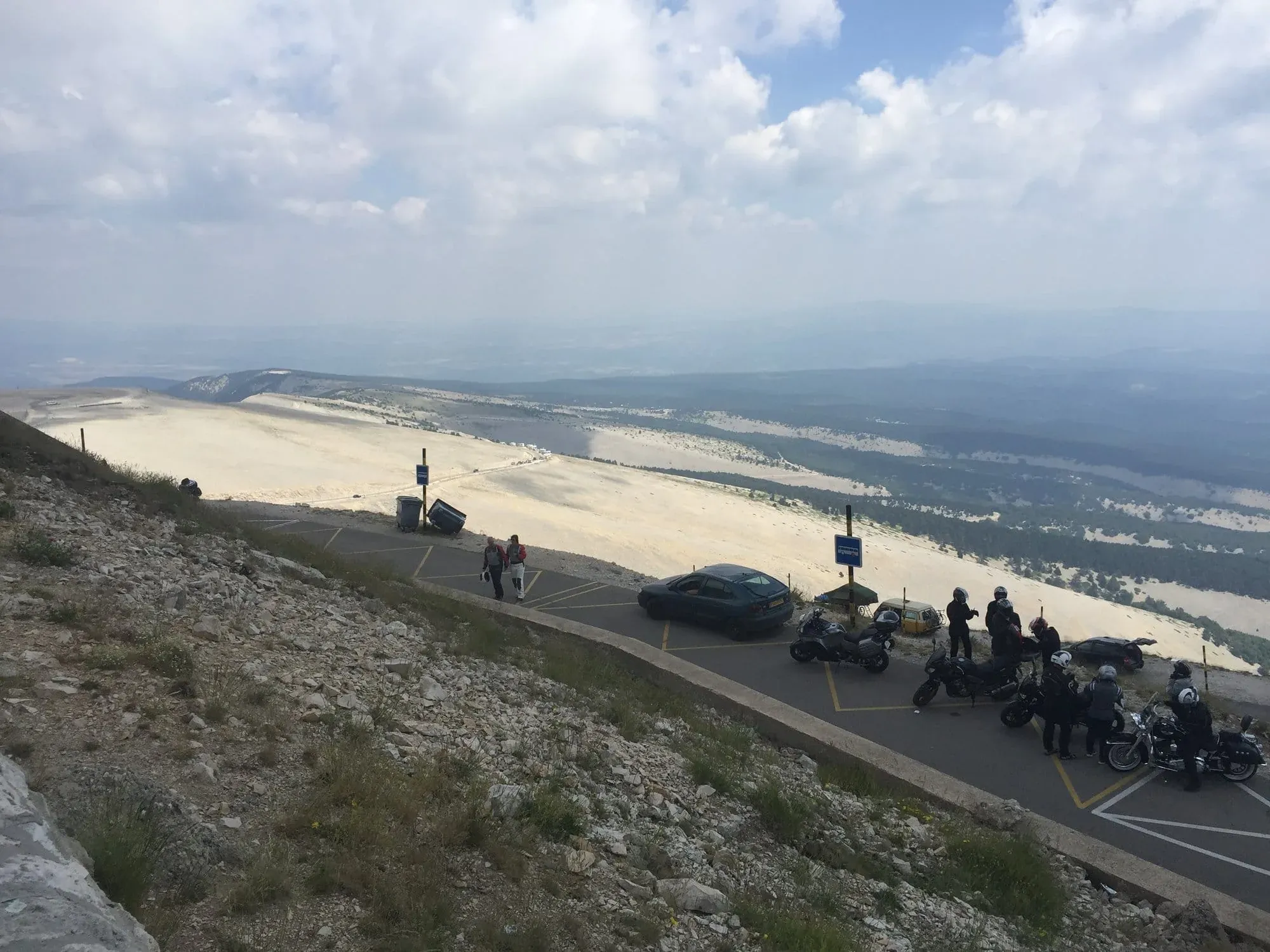 Motorcyclists and vehicles parked at scenic mountain overlook viewpoint
