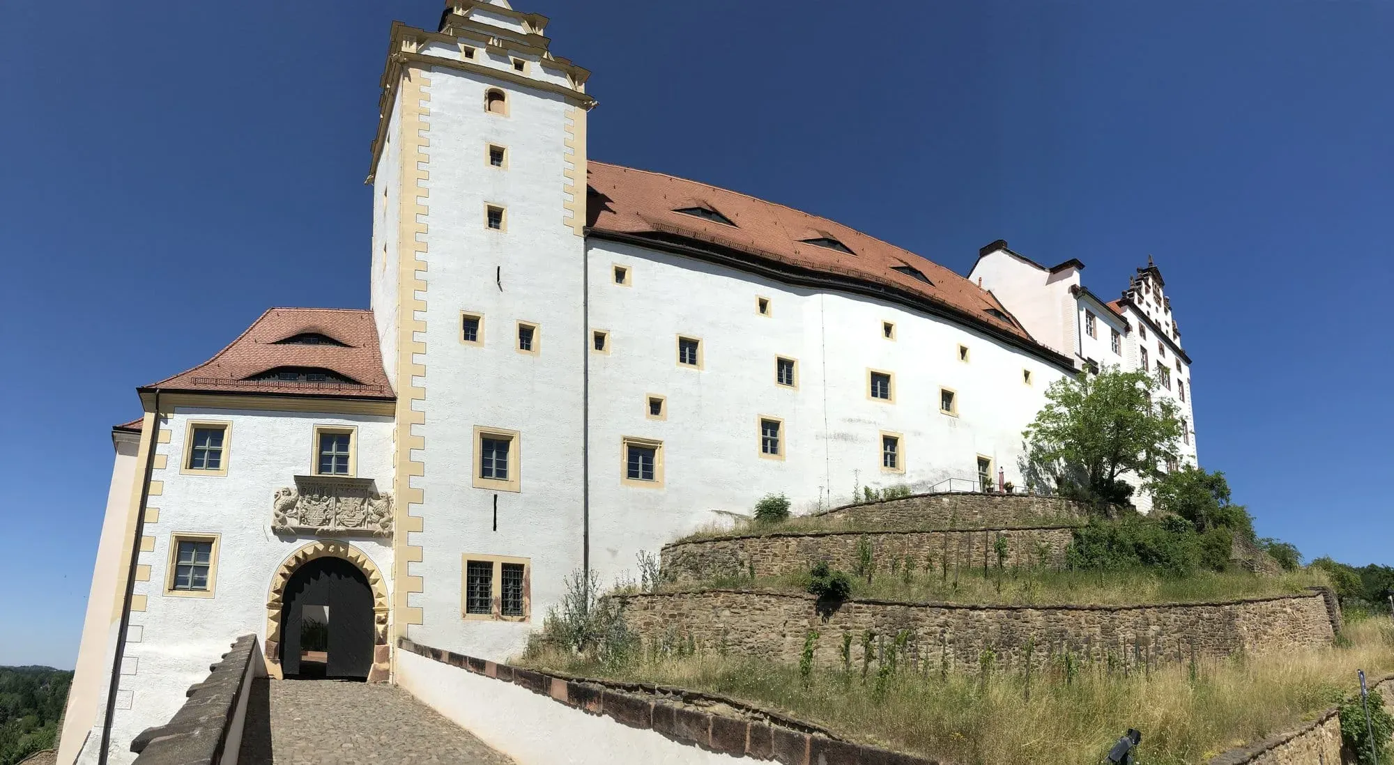 Medieval castle with white walls and tower on hilltop