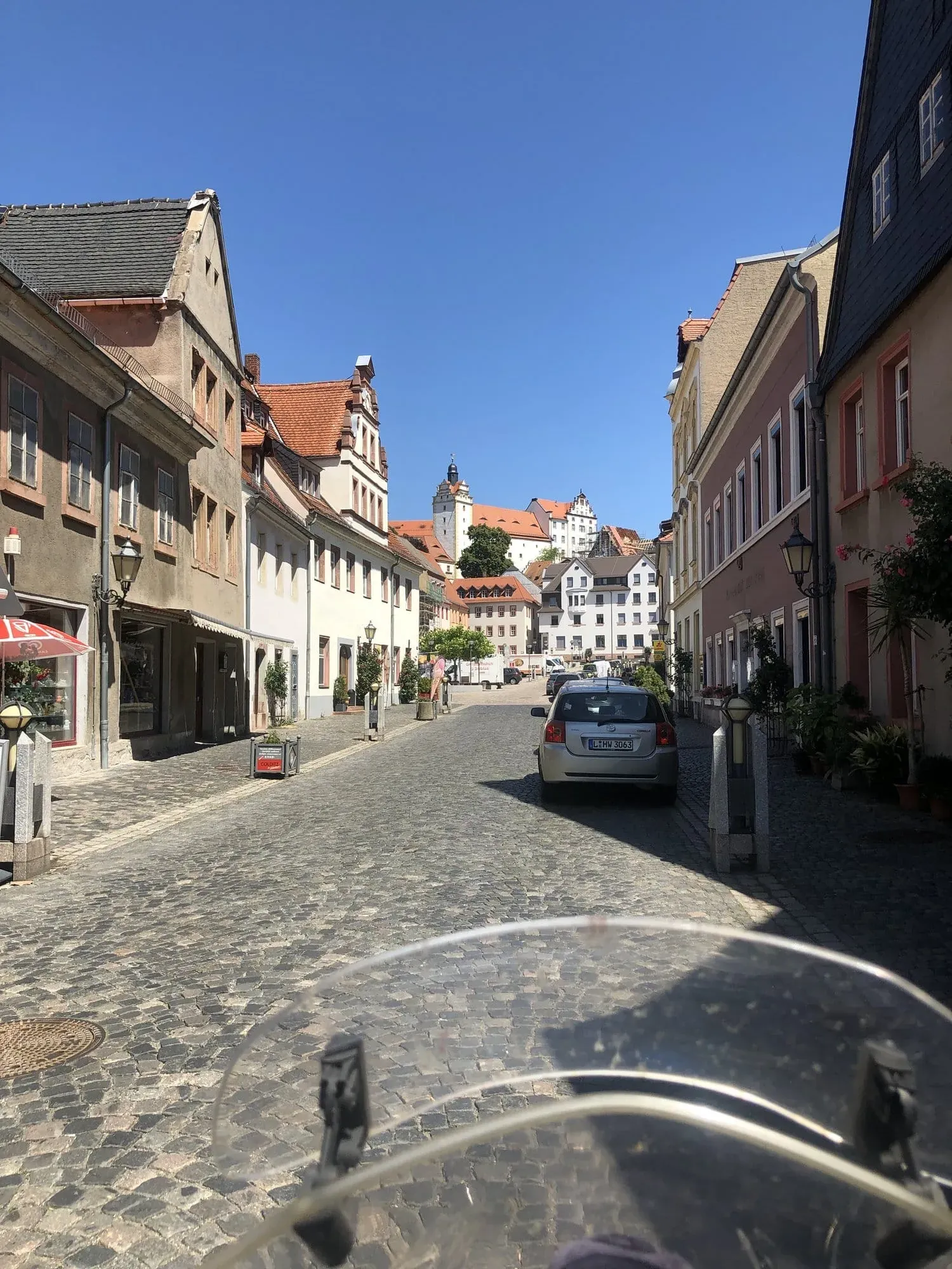 Historic European town street with castle tower in distance