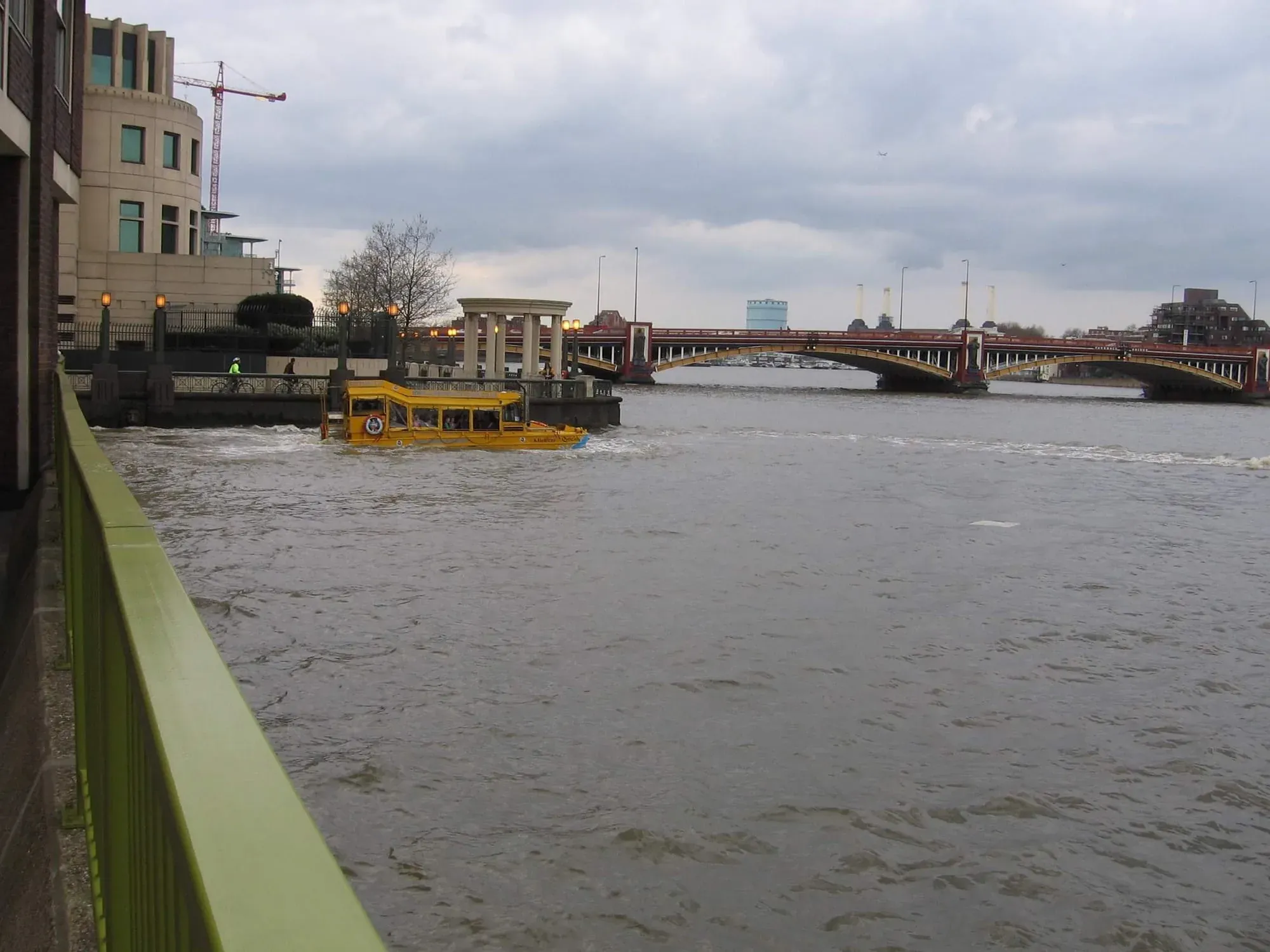 Yellow amphibious tour bus on flooded Thames near Blackfriars Bridge during high water