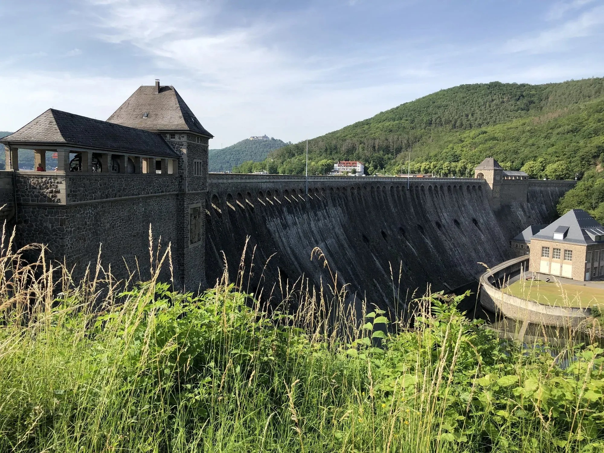 Historic stone dam with turret spanning forested river valley