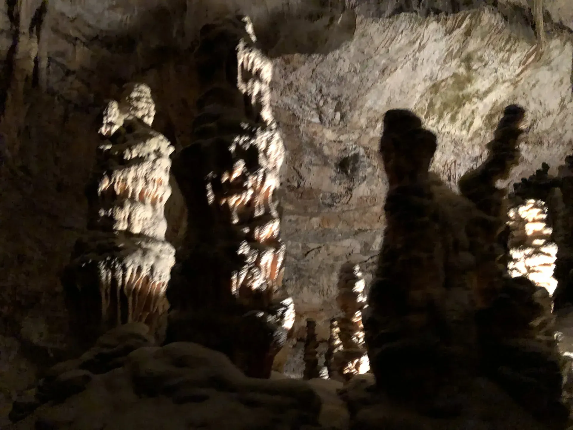 Silhouettes exploring cave formations at Sovič, Slovenia