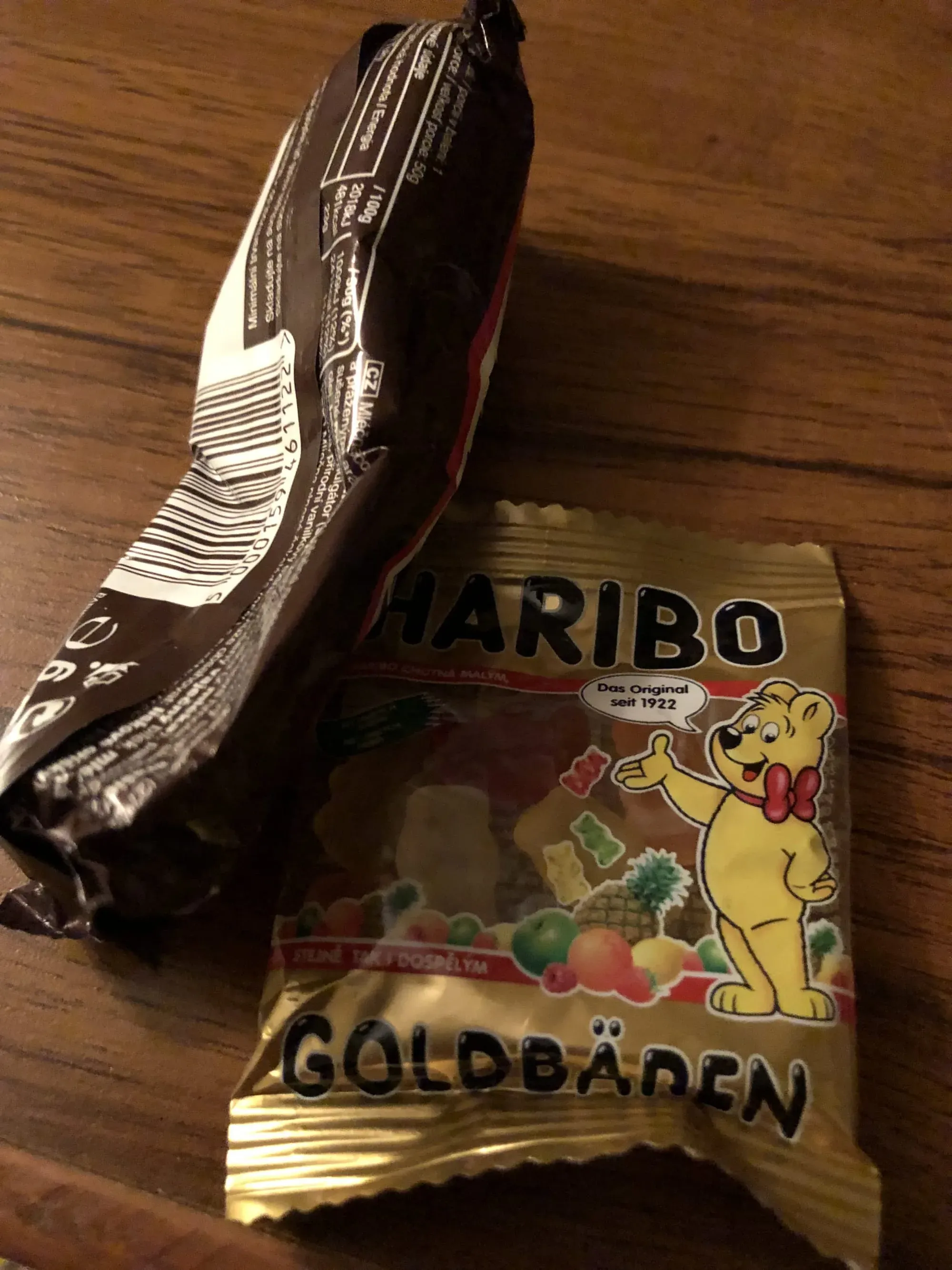 Haribo Goldbears candy package on wooden surface with black item
