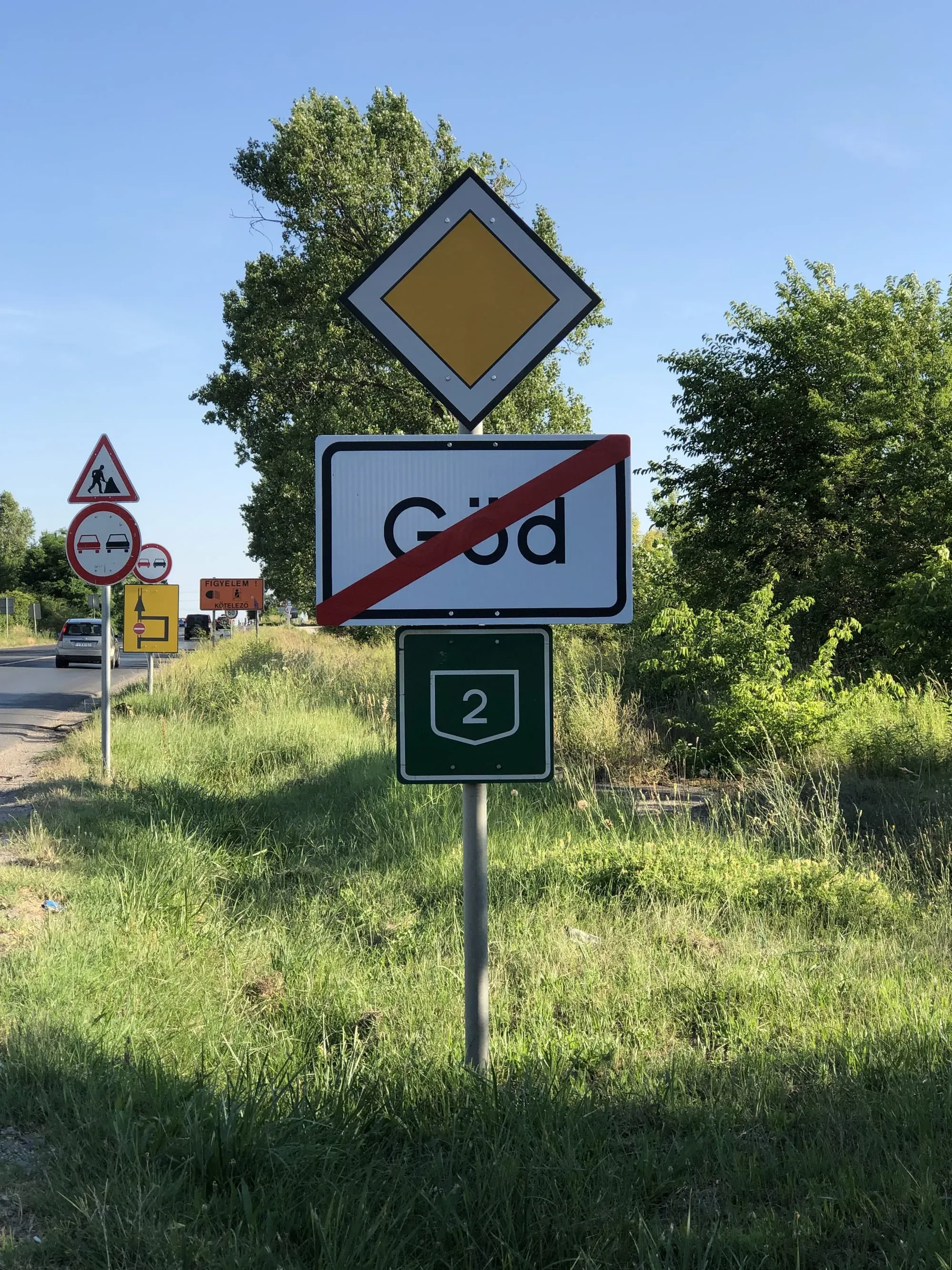 Road sign showing end of town with yellow diamond and route 2 marker
