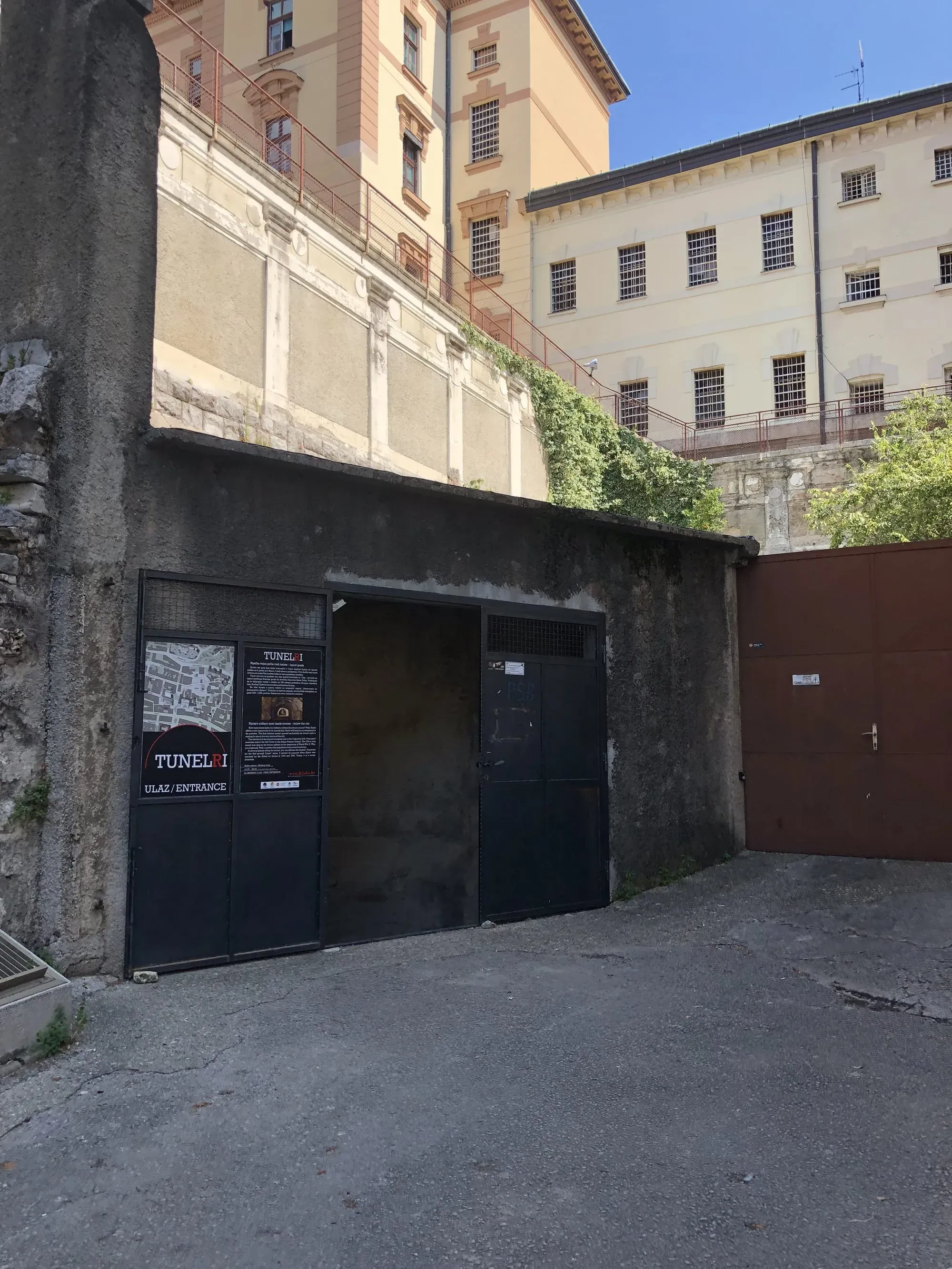 Black entrance door to Tunel 1 underground passage with information plaques