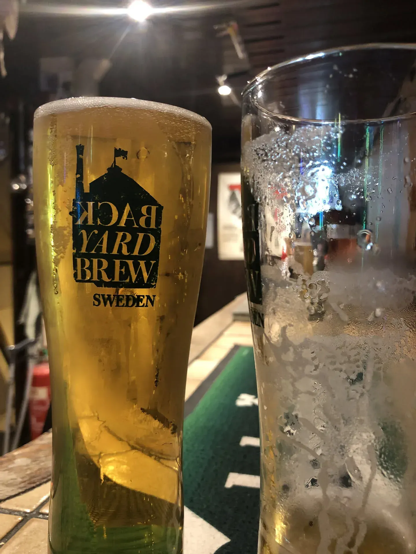 Backyard Brew Sweden beer glass next to water glass on table