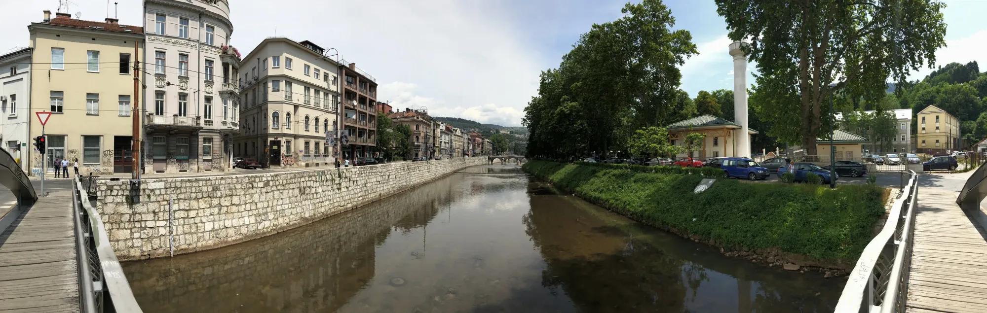 River running through Baščaršija with historic buildings